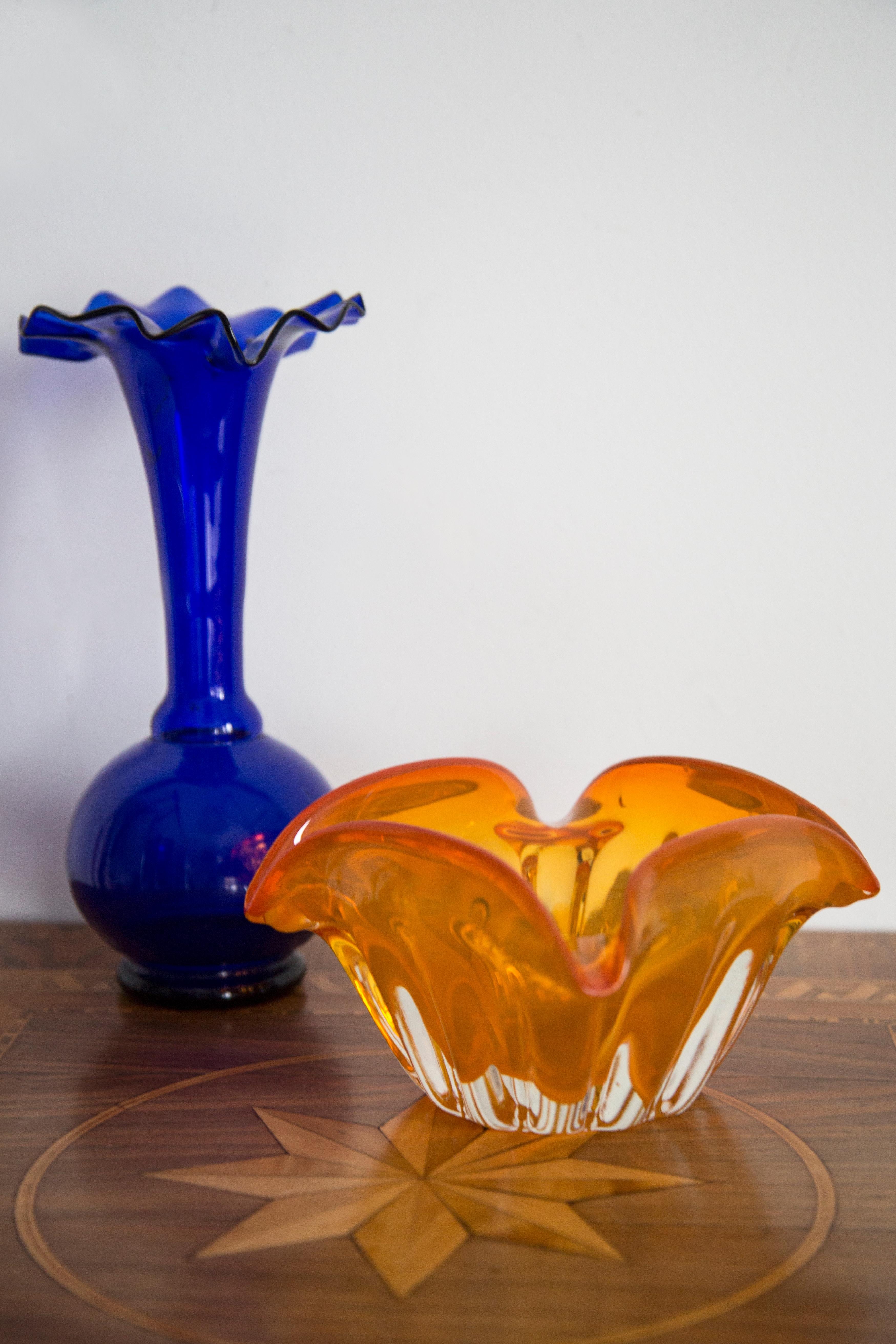 Este original elemento vintage de cristal para cenicero fue diseñado y fabricado en la década de 1970 en Lombardía, Italia. Está fabricado en técnica Sommerso y tiene una fantástica forma facetada. El color vibrante hace que este artículo sea muy