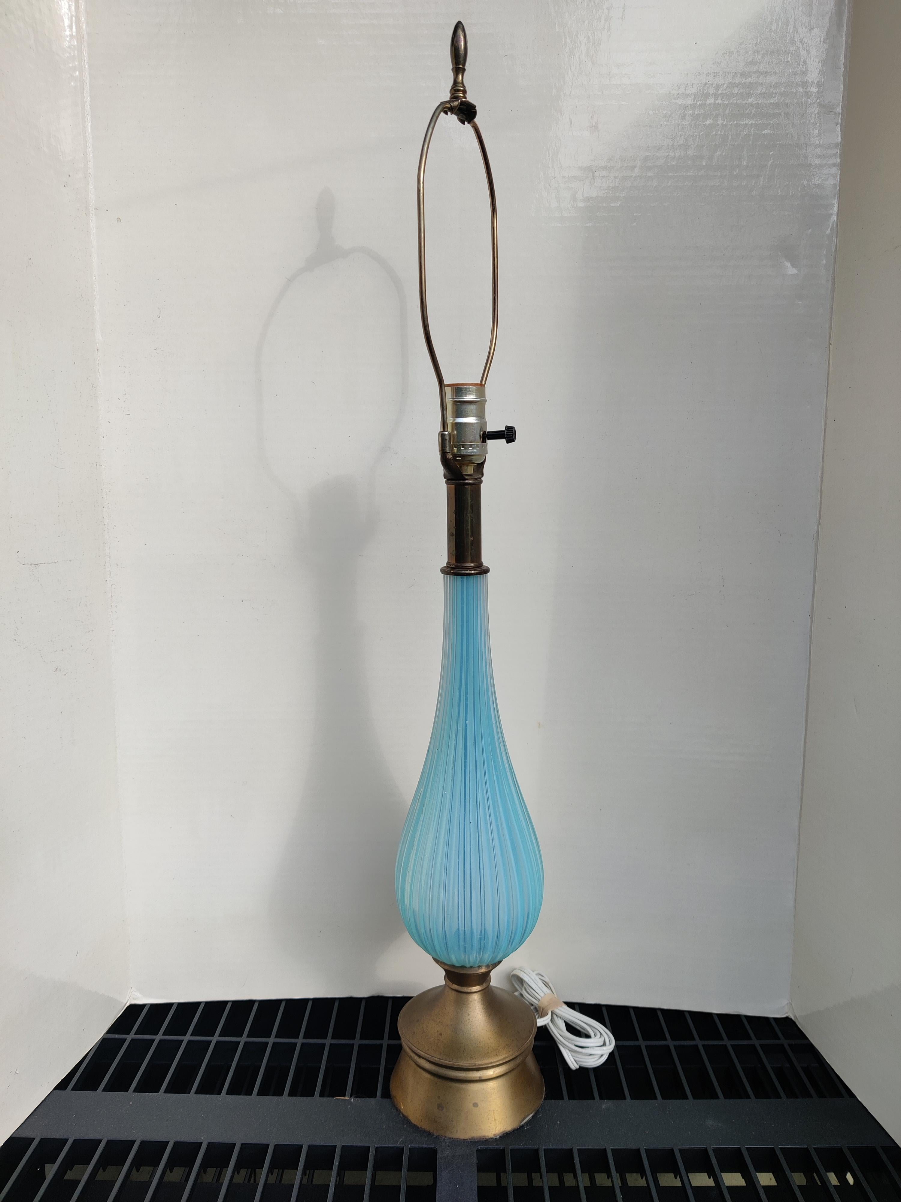 Mid Century Murano Periwinkle Fluted Glass Lamp
Base has tarnish from age.
No damage to glass.
Brass finial.
H - 31.5 base to finial
Base - 4.5 x 4.5 
Glass - 12 x 4.5