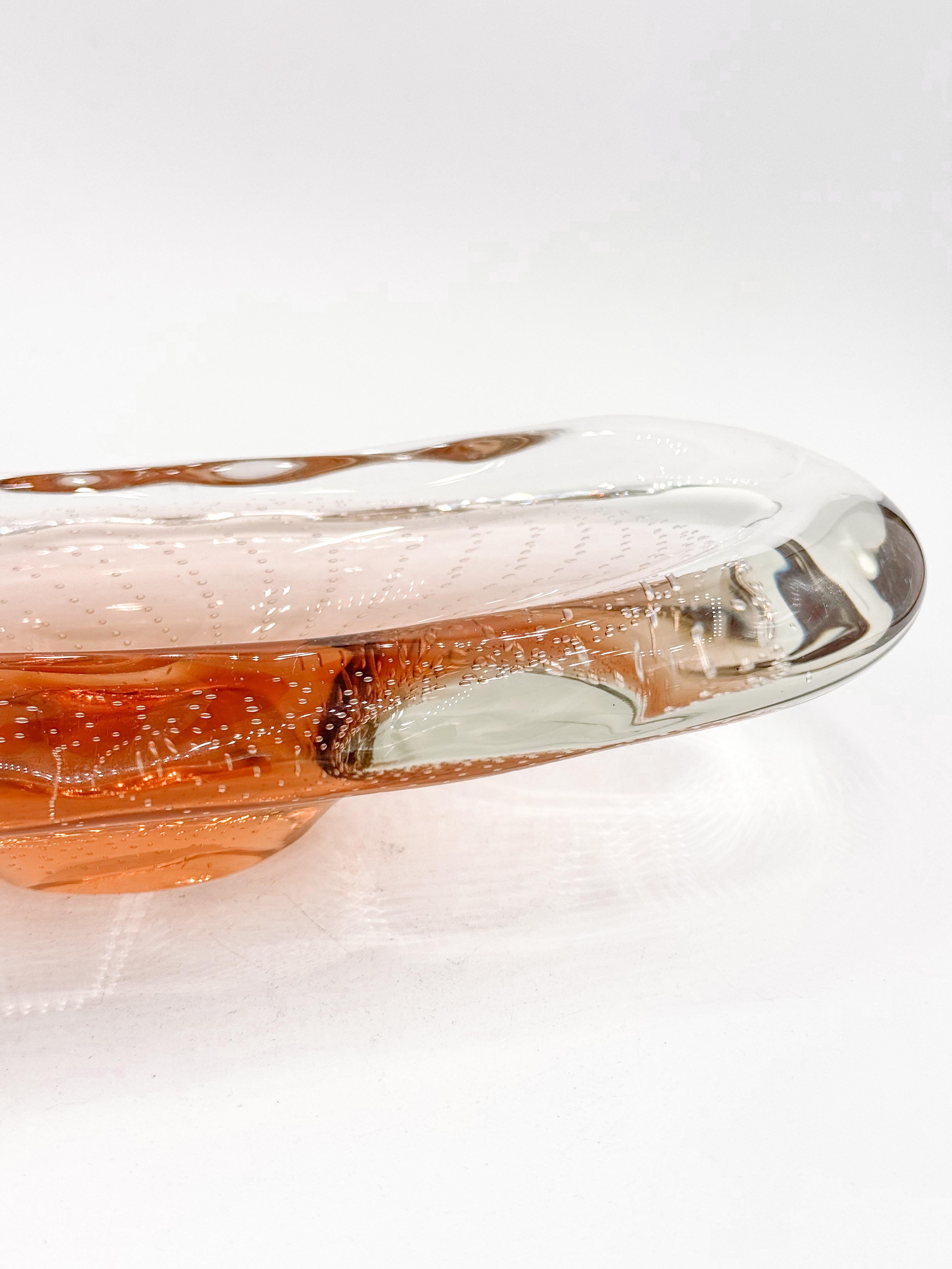 An exceptional mid-century Murano glass vide-poche, finely handblown with remarkable clarity and weight. This sculptural piece is crafted from thick, heavy glass and features an elongated oval form highlighted by a warm amber core. Throughout the