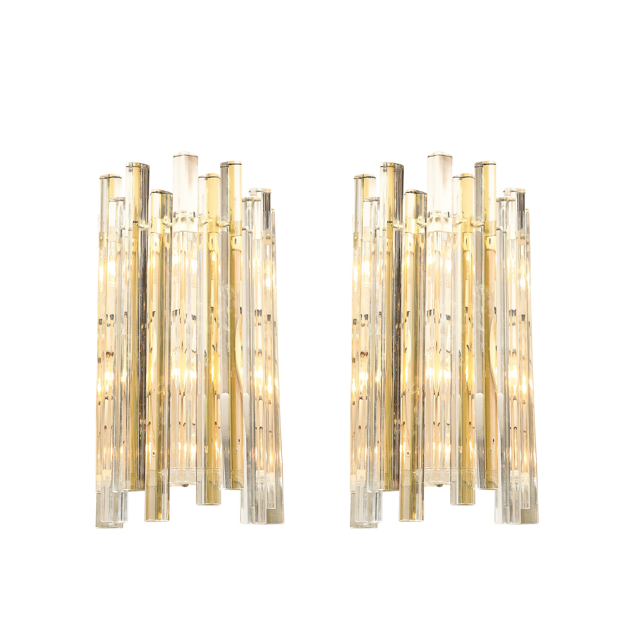 Crafted by the renowned Venini in Italy around 1970, this pair of mid-century modernist sconces epitomizes elegance and artistry. Featuring hand-blown Murano glass in a distinctive stepped triedre design, the muted green and clear hues create a