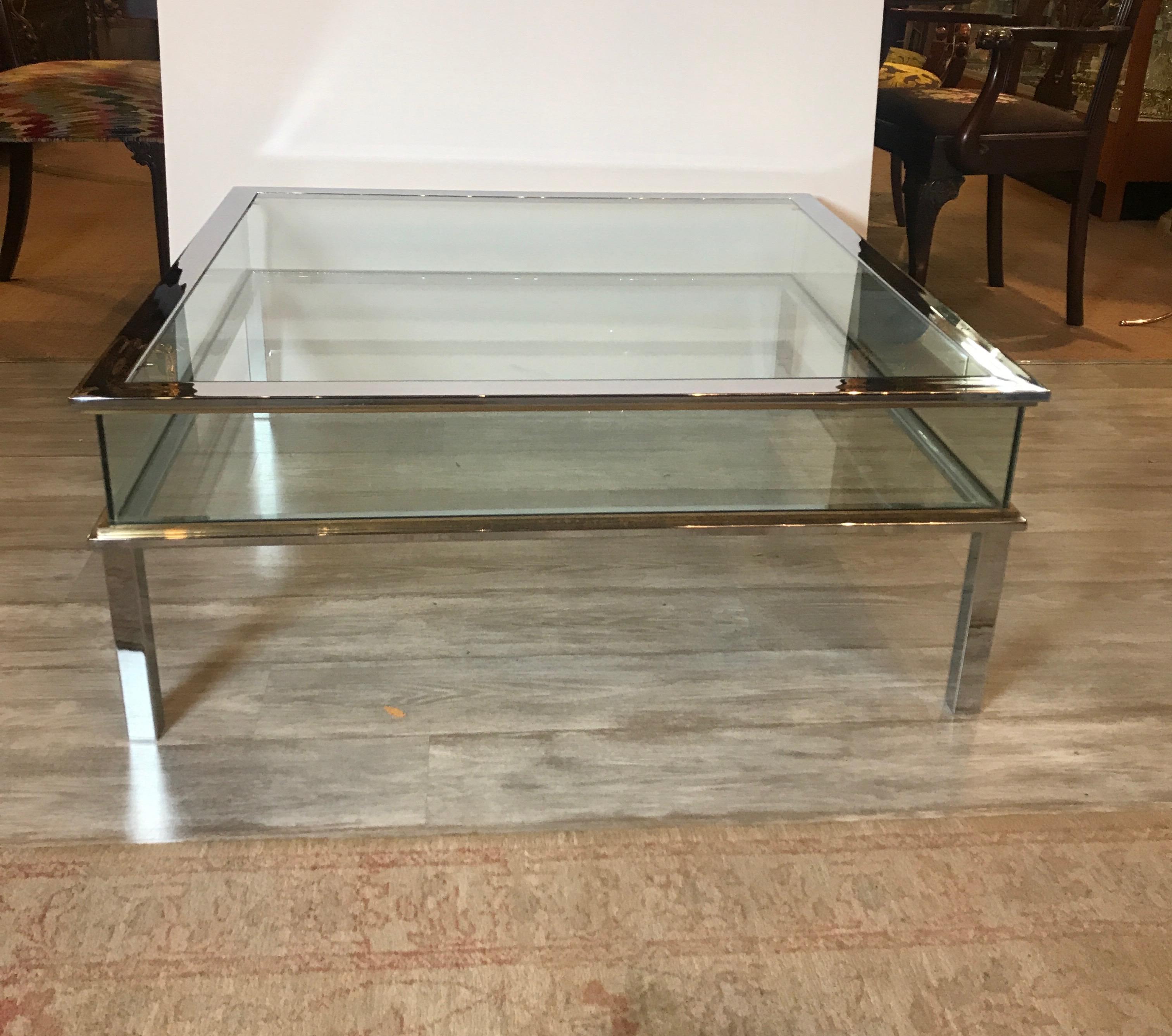 Grande table basse carrée en laiton chromé et verre de musée. L'espace d'exposition généreux avec des plateaux et des côtés en verre soutenus par des pieds chromés avec des accents en laiton. À la manière de la Maison Jansen.