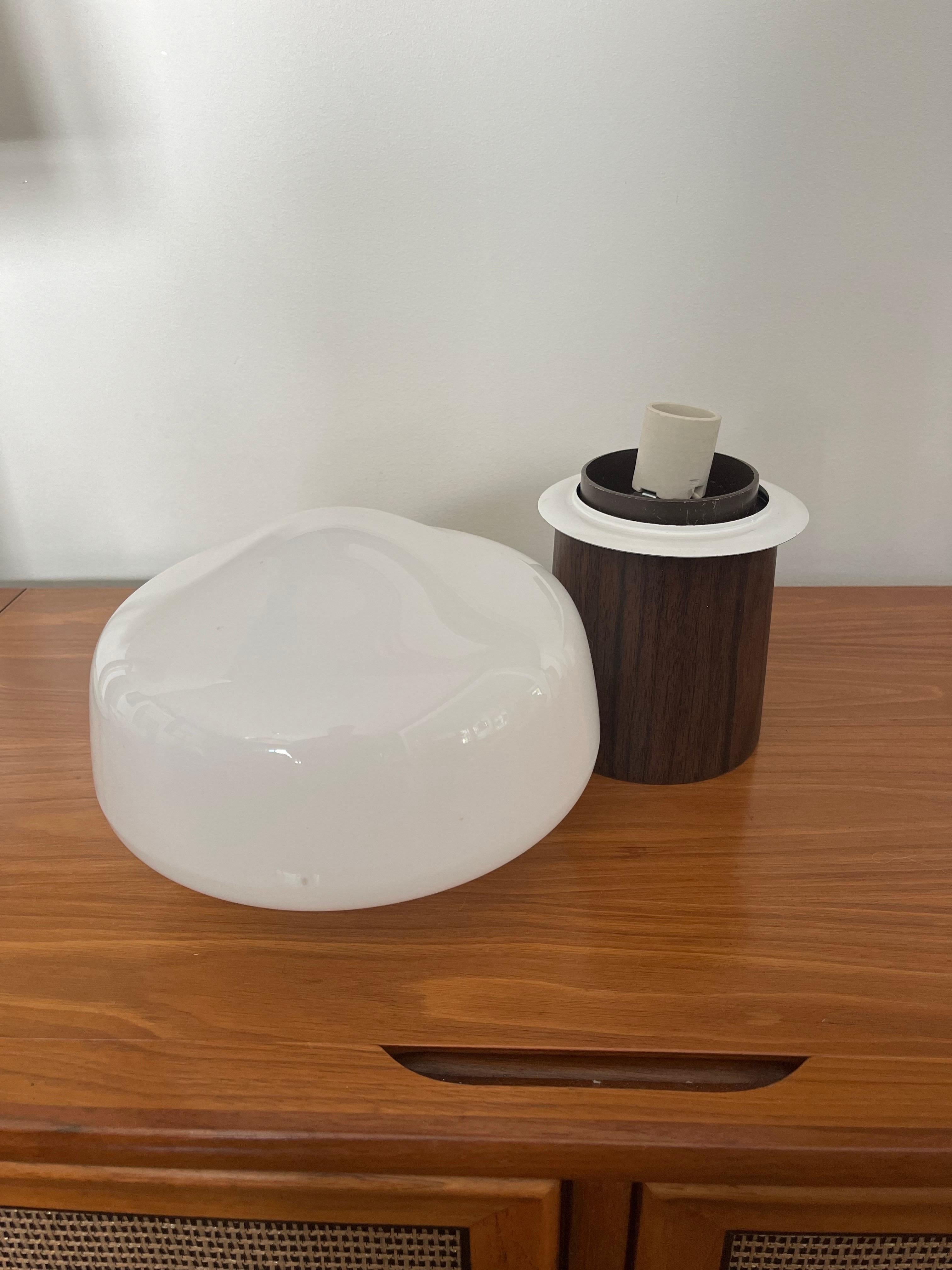 Classic mid century Mushroom Lamp. Faux wood grain base with toggle switch and white mushroom shade. White metal collar shades sits atop. Beautiful piece to round out your chic space.