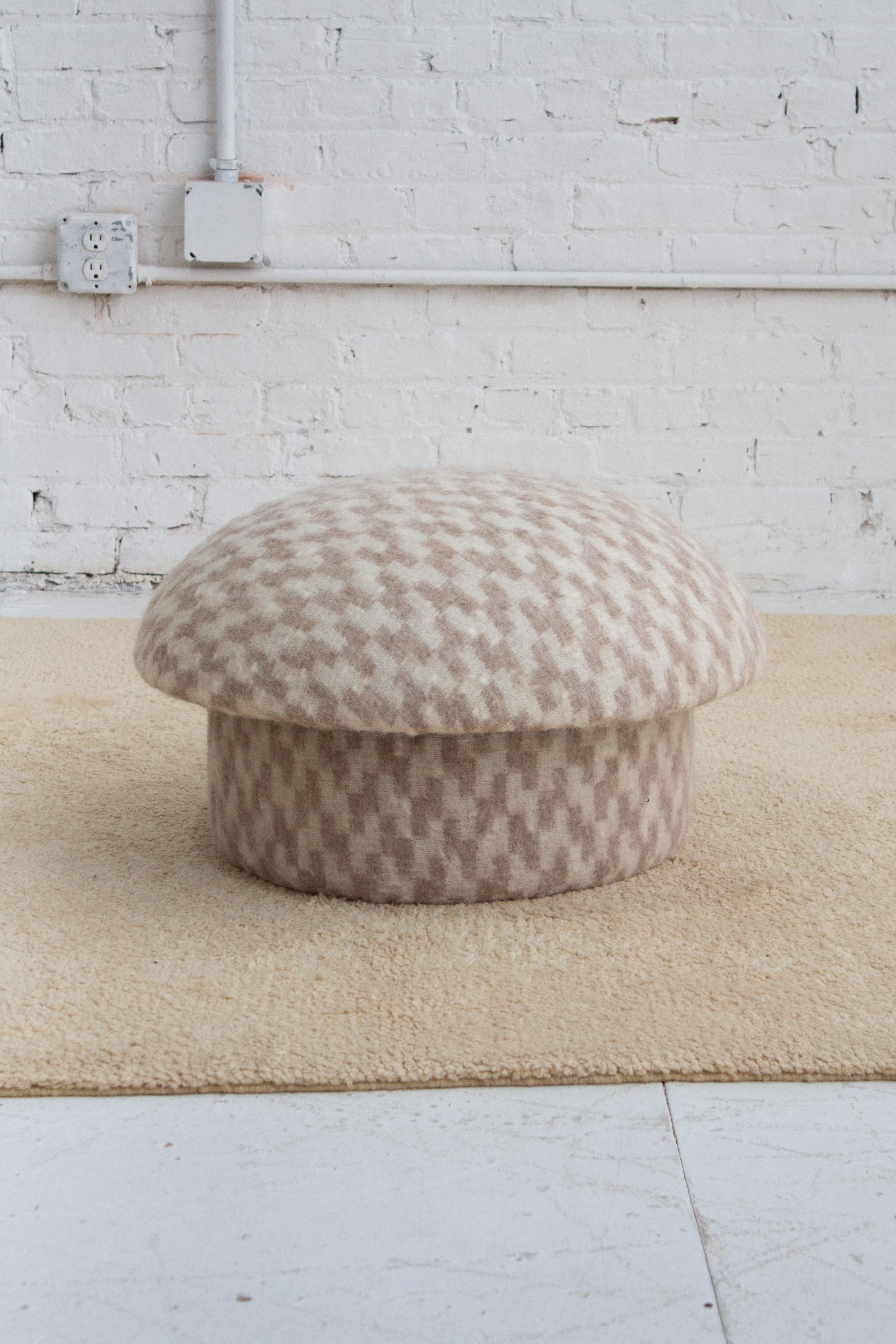A classic mid century mushroom ottoman. Newly reupholstered in a cream and beige textured wool fabric.