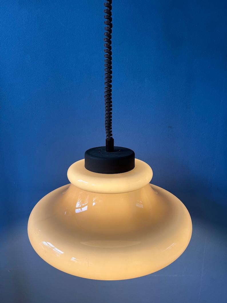 A space age pendant lamp by Herda with a beige, acrylic glass mushroom shade. The height of the lamp can be adjusted with the rise-and-fall system.

Additional information:
Materials: Metal, plastic
Period: 1970s
Dimensions: ø 35 cm
Height Shade: 25