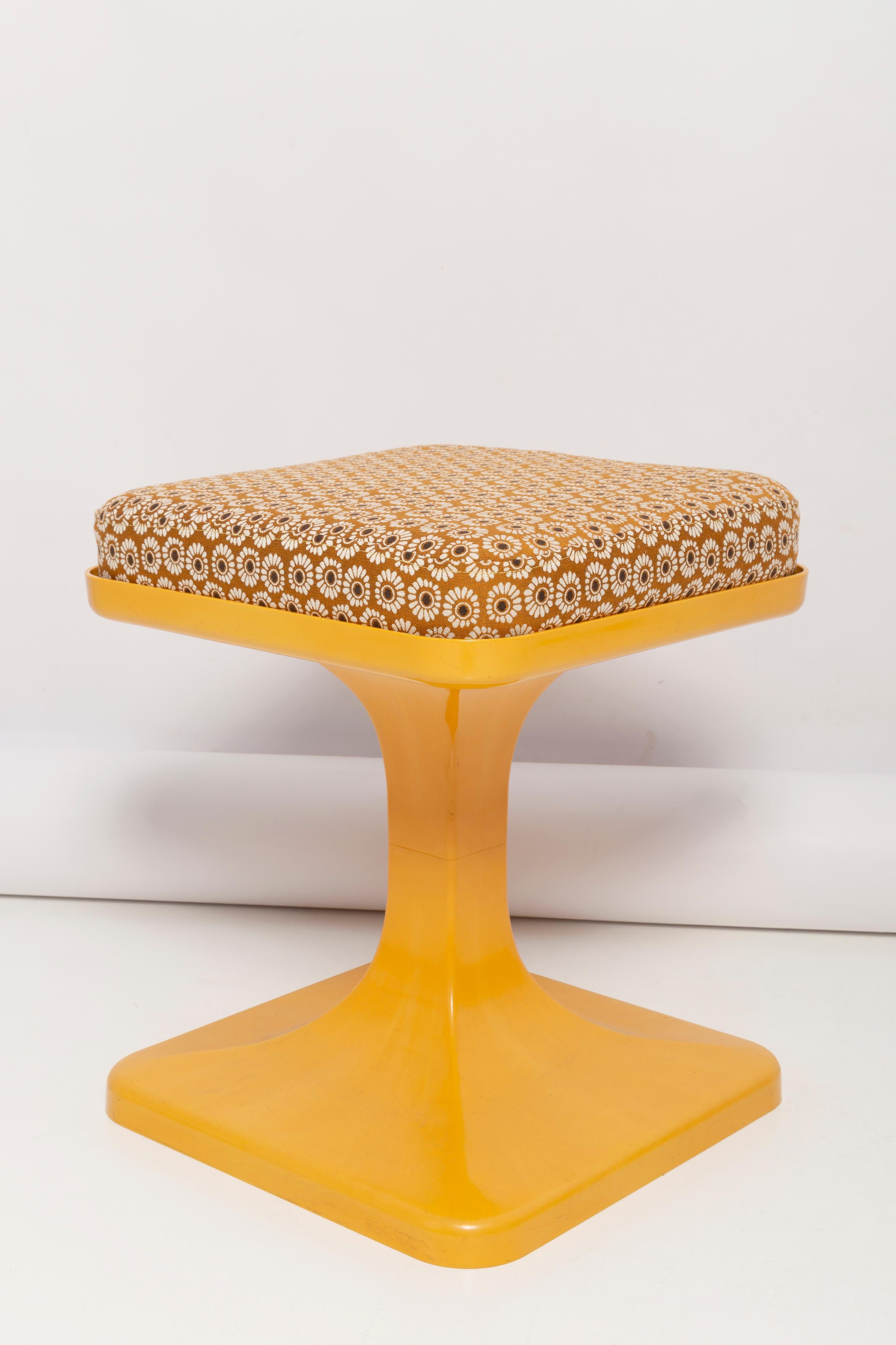 Space Age style plastic stool was made in Poland by Krynwald ERG fabric around the 1960s-1970s. The futuristic shape is tapered and aerodynamic, with a tulip foot and an yellow mustard color. This original piece in hard plastic imitates the texture