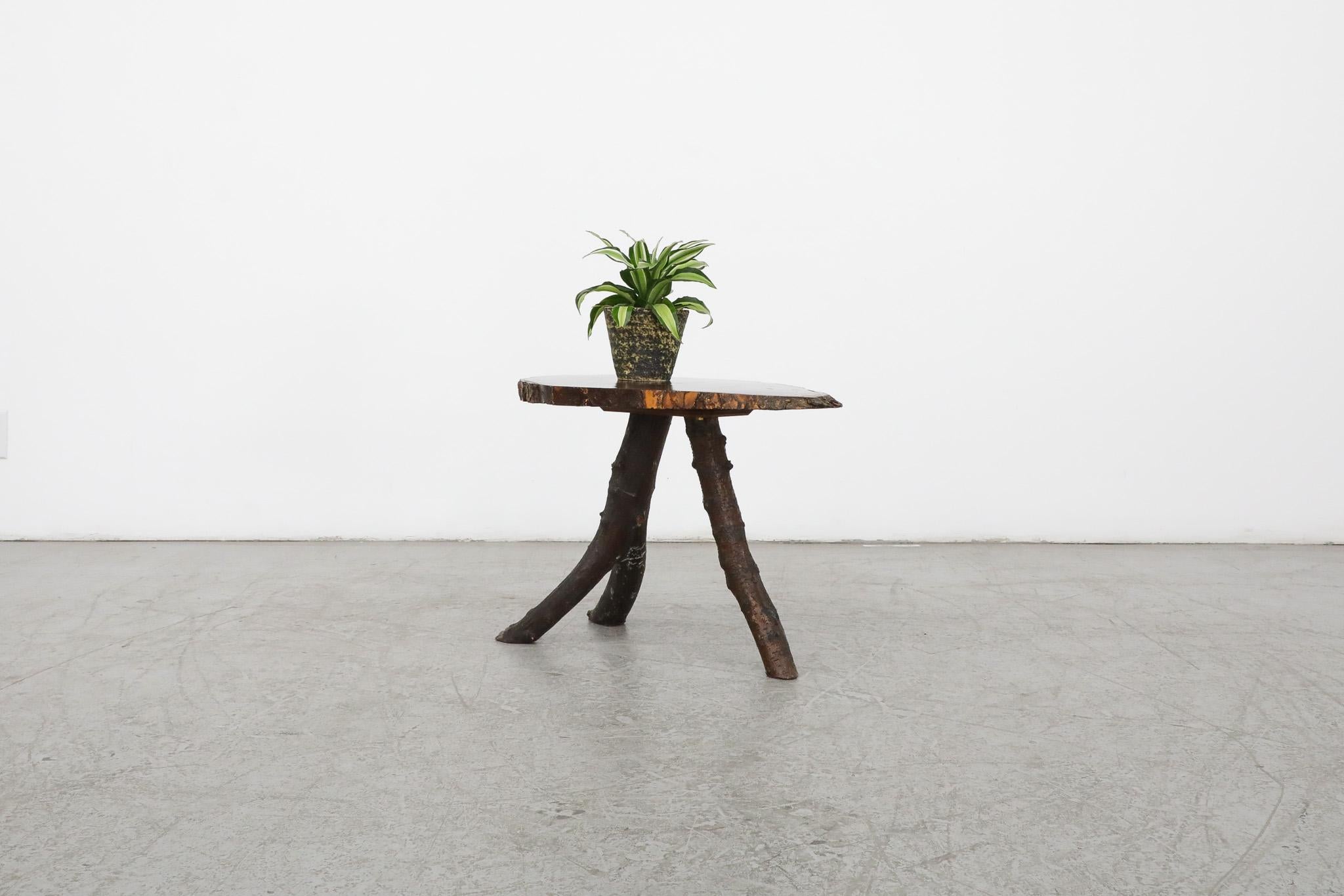 Nakashima style live edge tree side table with bark on organic shaped table top and three branch legs. Stunning natural, simplistic design. In original condition with visible wear consistent with its age and use.