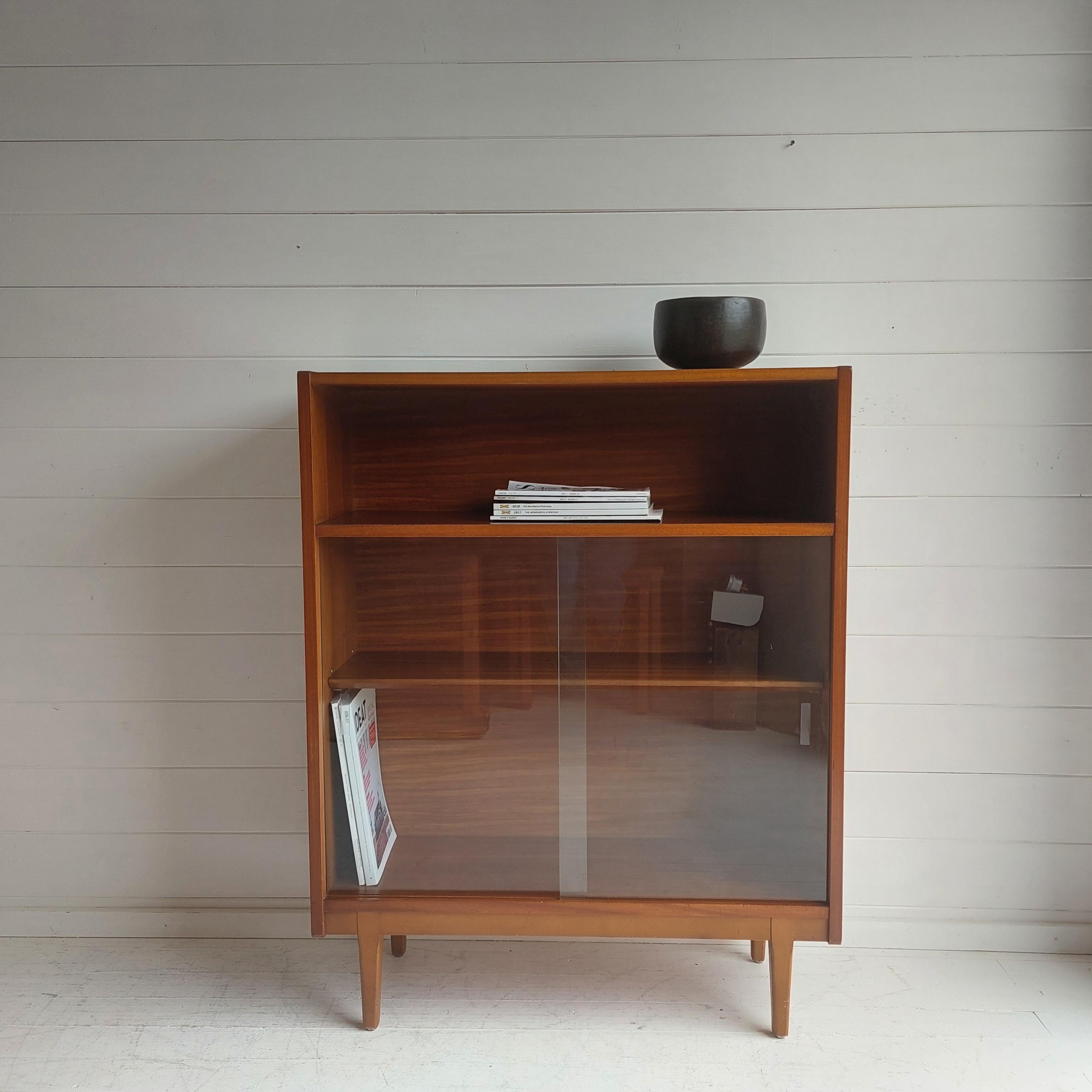 Midcentury retro style! 
1960s teak sideboard / bookcase designed by Nathan Furniture.

A lovely teak bookcase cabinet with sliding glass doors. 
A simple stylish piece that will provide a useful storage space in the modern home. 
A stunning