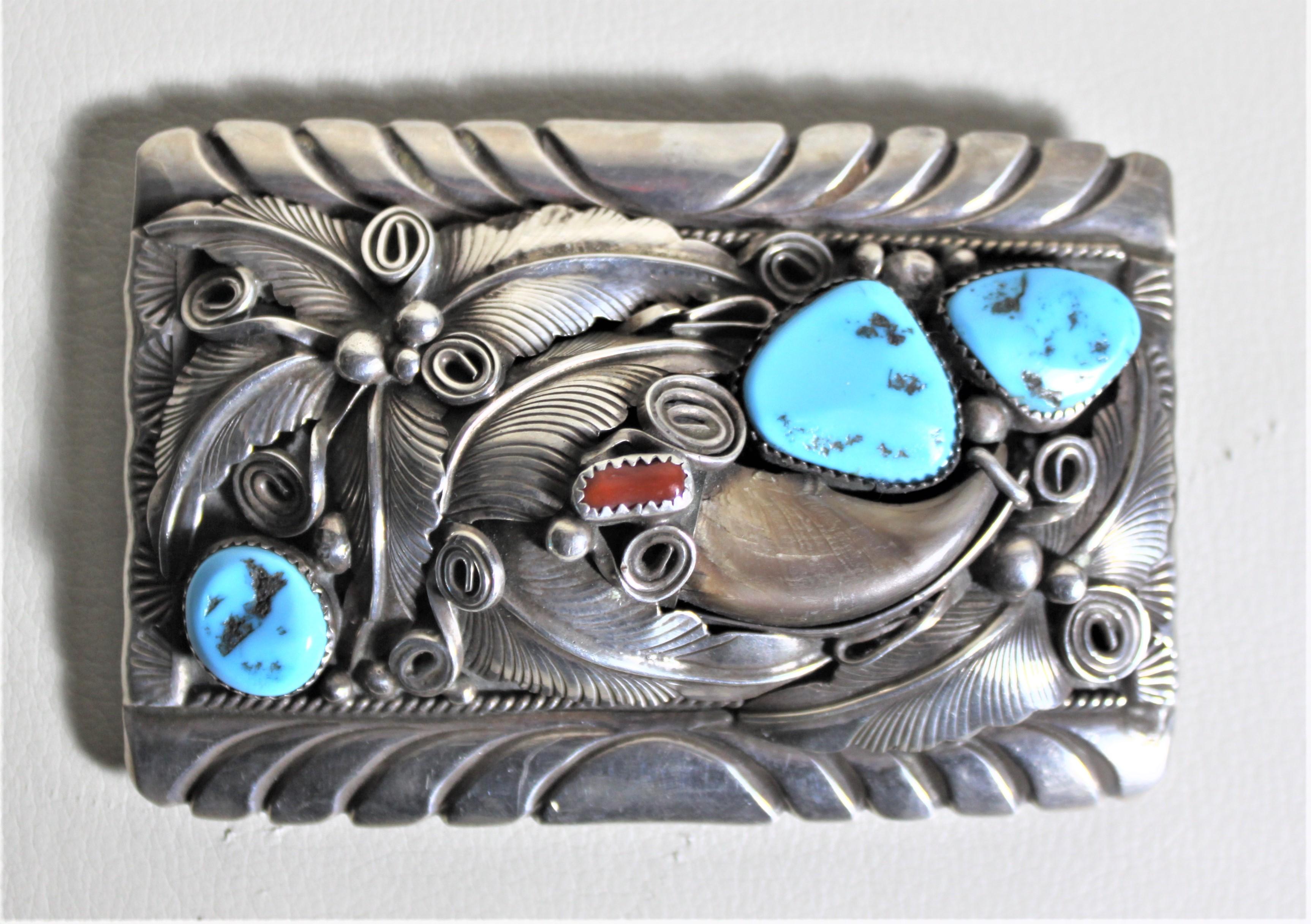 This sterling silver and turquoise belt buckle is signed M. Thomas Jr., a known Indigenous American silversmith and done in his signature Navajo style. This large and substantial buckle is intricately hand-crafted with sterling silver with inlaid