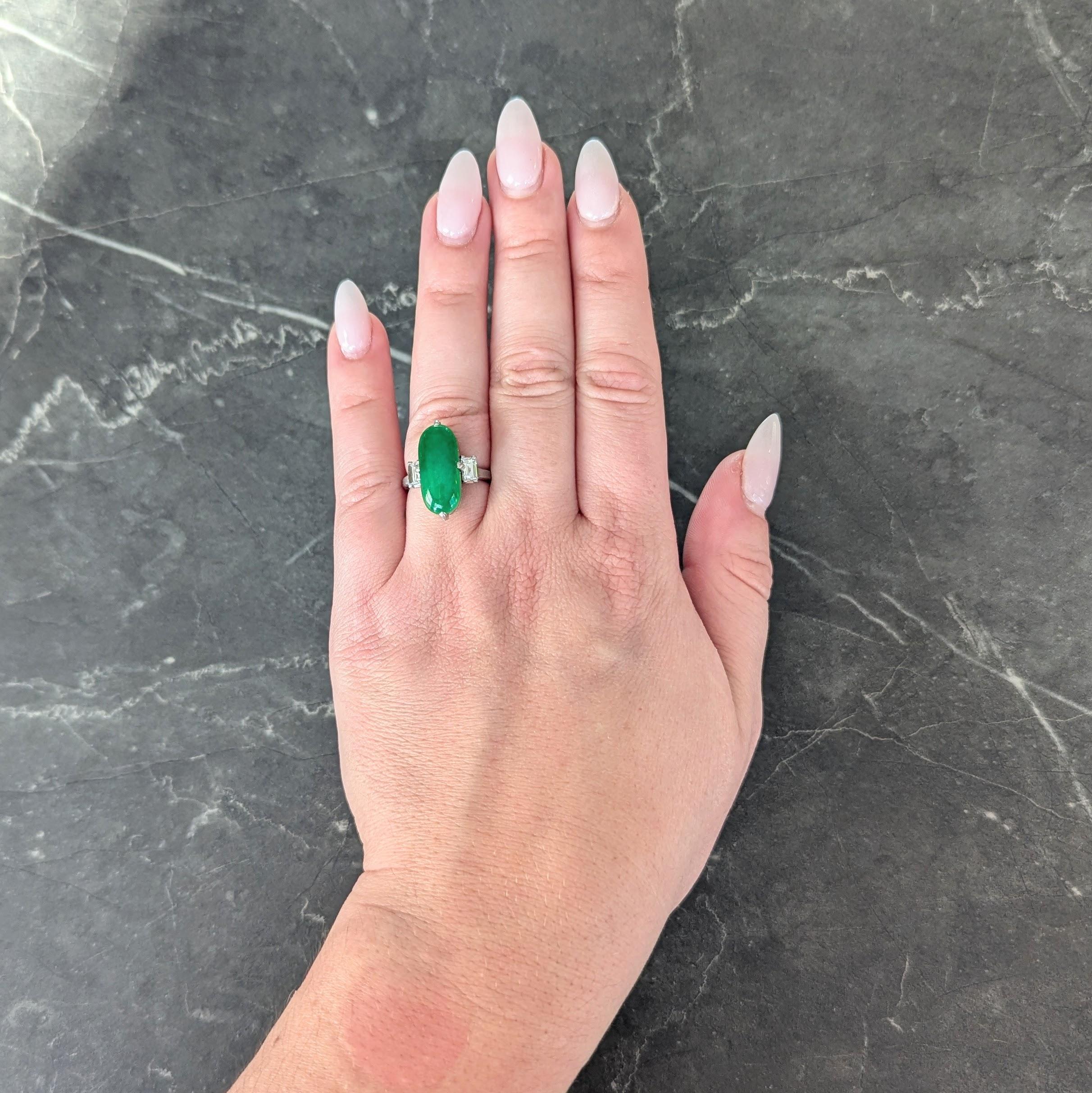 Centering an elongated oval shaped jade cabochon measuring 7.85 x 17.80
Natural type A (Fei Cui) and displaying no signs of dye or impregnation
Translucent medium vibrant green in color - prong set in pieced basket
Flanked by pierced scroll motif