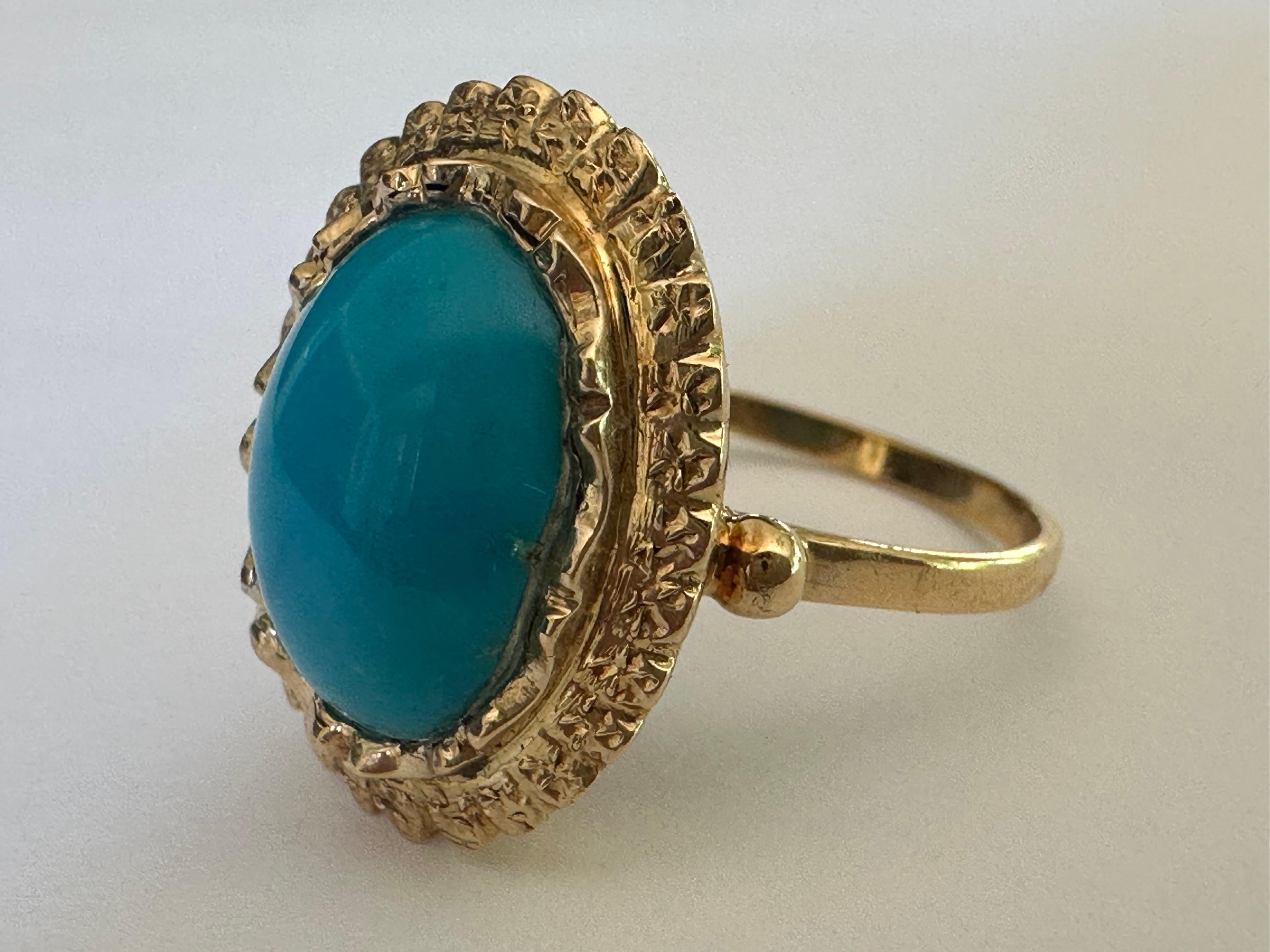 Realizzato negli anni '50, questo anello di metà secolo presenta un turchese naturale di forma ovale che misura 14x10 mm e pesa circa 6,05 carati. Il turchese cabochon è circondato da due file di oro giallo 18 carati delicatamente traforate in un