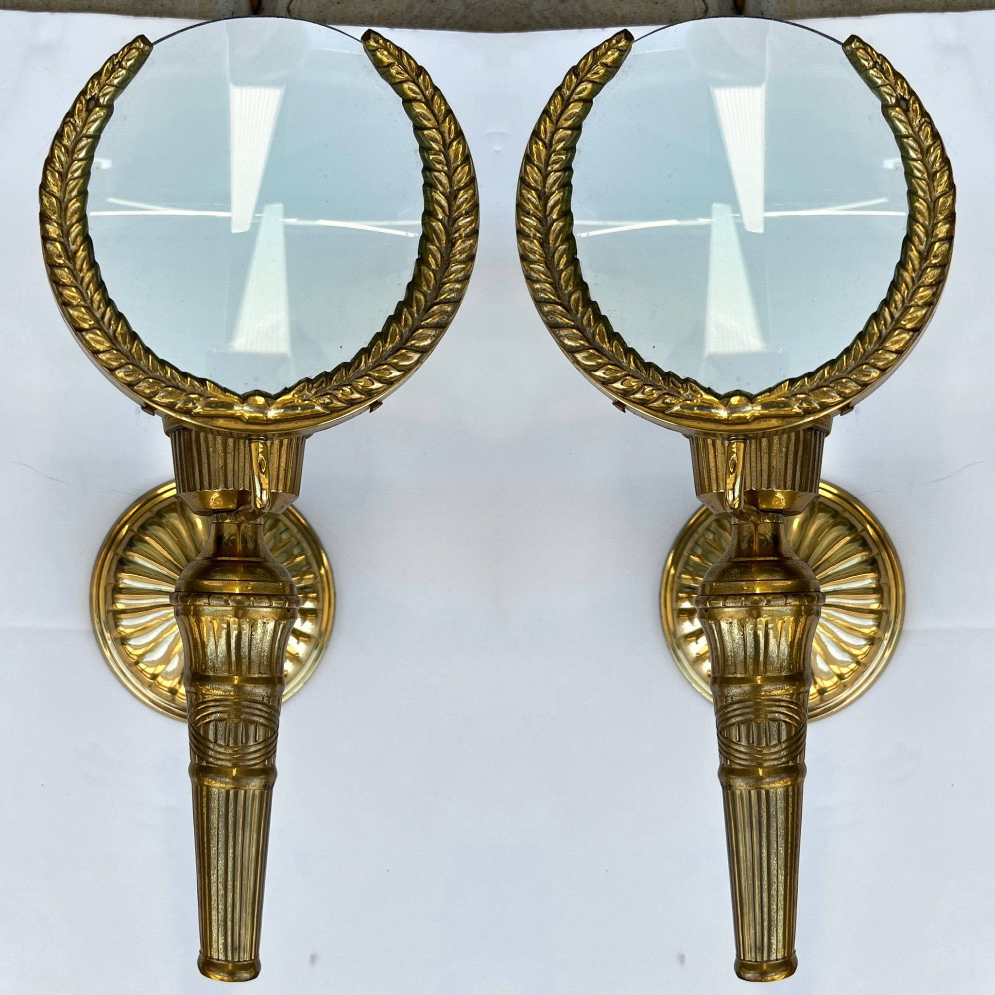 This is a pair of mid-century cast brass magnifying glass sconces. They are not electrified and are unmarked. They are in very good condition.