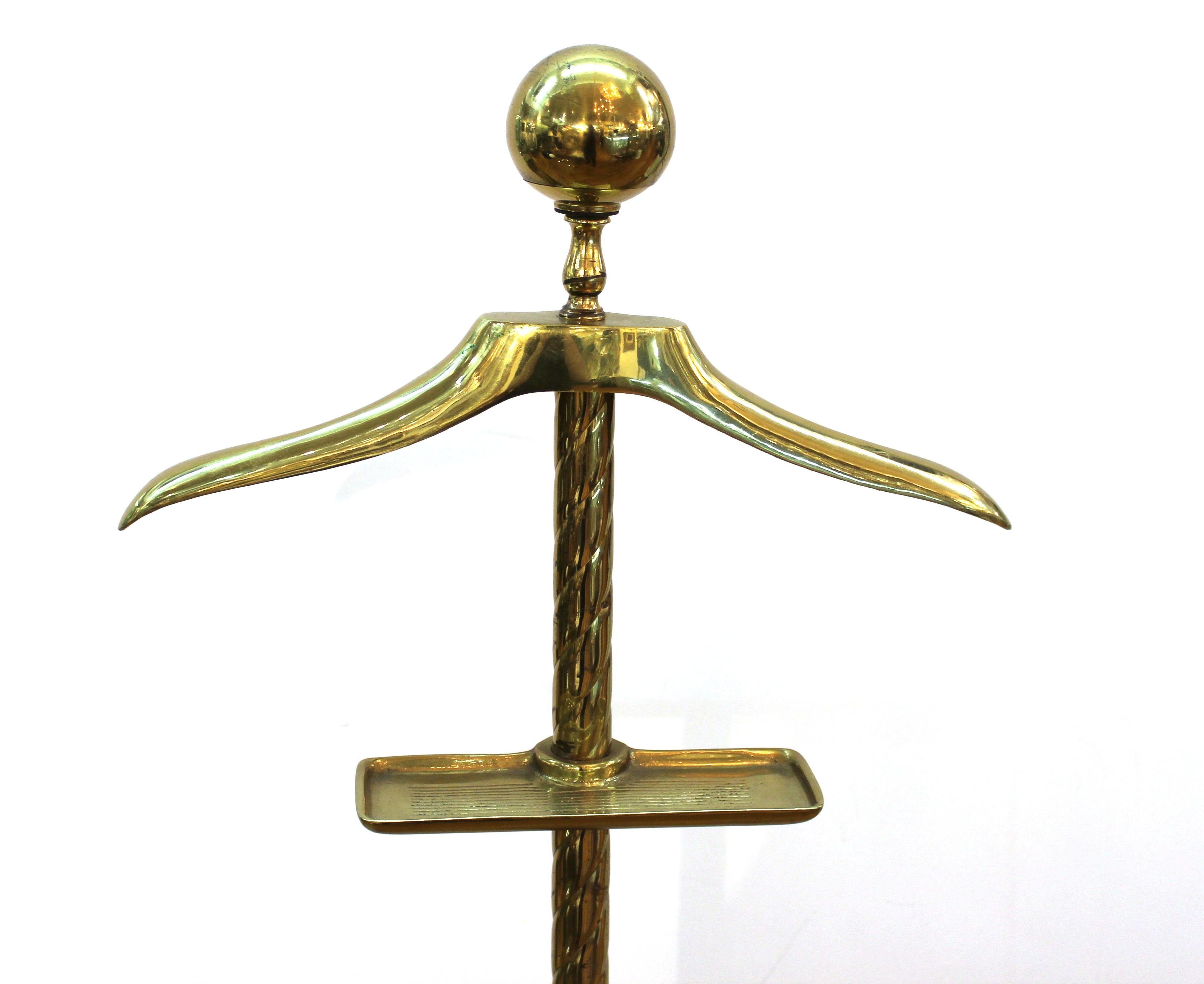 Mid-century neoclassical style brass valet with adjustable hanger and vide-poche elements.