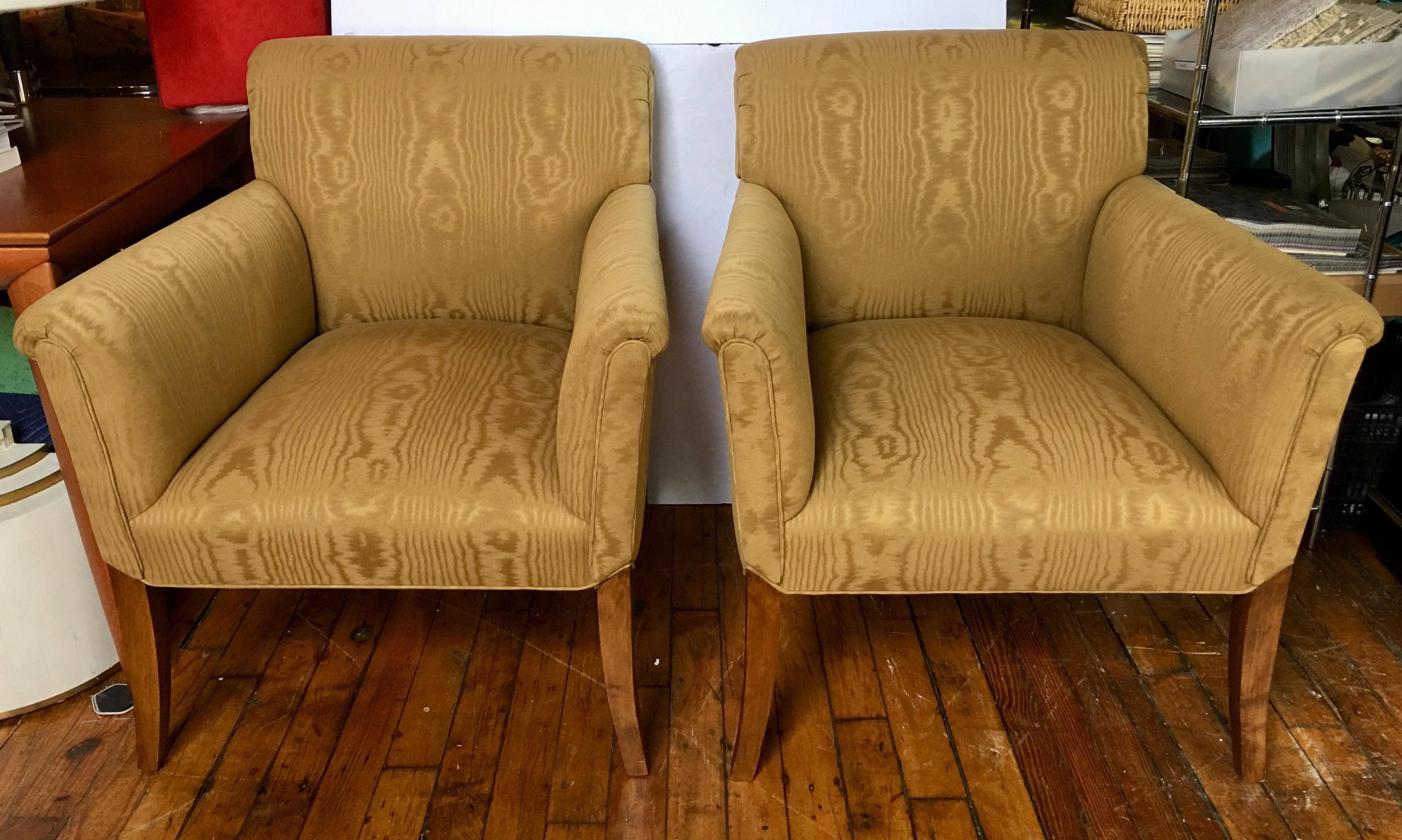 Perfectly proportioned pair of classic gold moire upholstered tight-back arm accent chairs featuring gently flared arms and legs. These generously sized pair of lounge chairs have subtle rolled arms and backs and beautifully curved walnut wood legs.