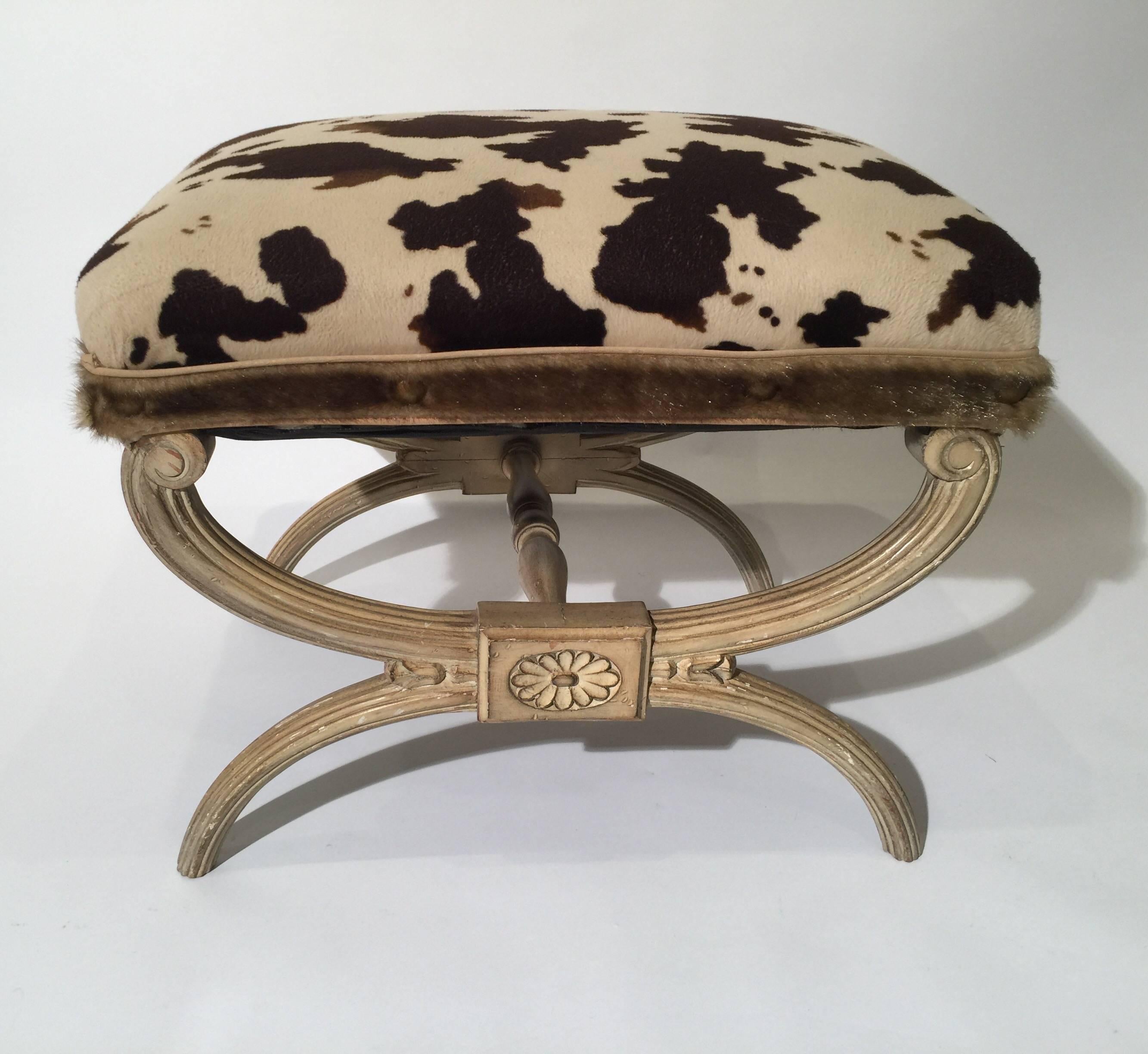 Midcentury neoclassical X-bench with faux cowhide animal print upholstery,
High style designer X-bench with hand carved painted wood base. The fabric is a short plush animal print covering with a faux fur trim. Italian, mid-20th century.
