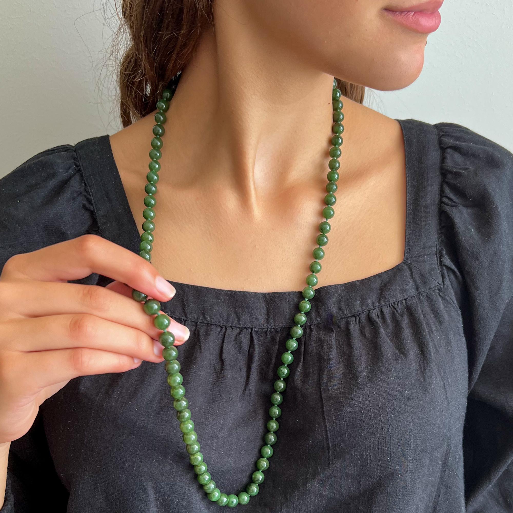 Eine schöne einreihige Perlenkette aus grüner Nephrit-Jade. Die Halskette ist lang und besteht aus runden Nephrit-Jadesteinen. Die Jadeperlen haben eine schöne grüne Farbe und sind gleich groß. Damit zwischen den Perlen etwas Platz bleibt, wird der