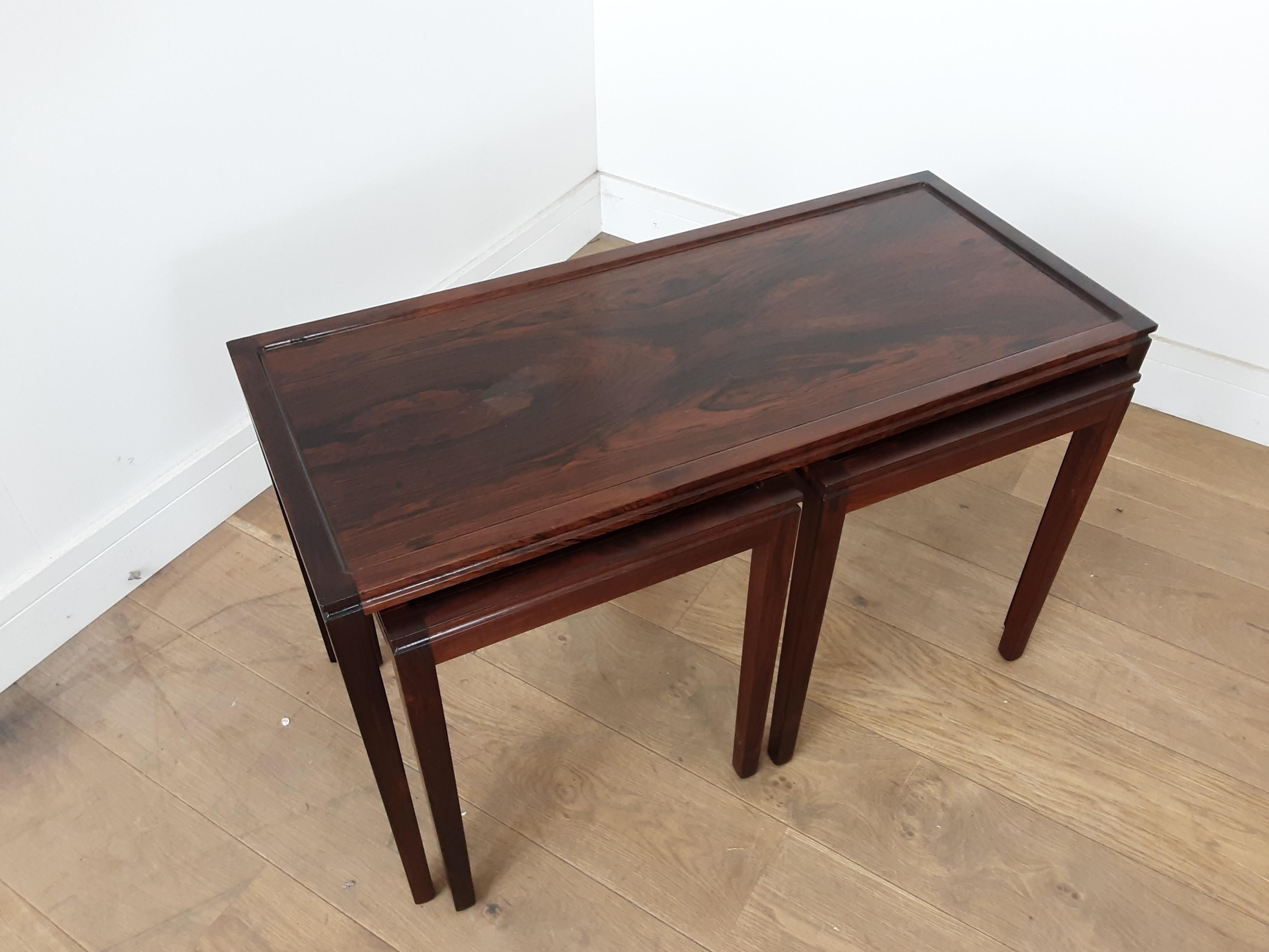 Midcentury rosewood nest of tables.
Midcentury nest of table in a beautiful rosewood.
Slightly raised edge with a good tooled curve into the centre sections.
The rosewood has a very nice grain to it.
Measures: Main table 48.5 cm H, 83 cm W, 36.5