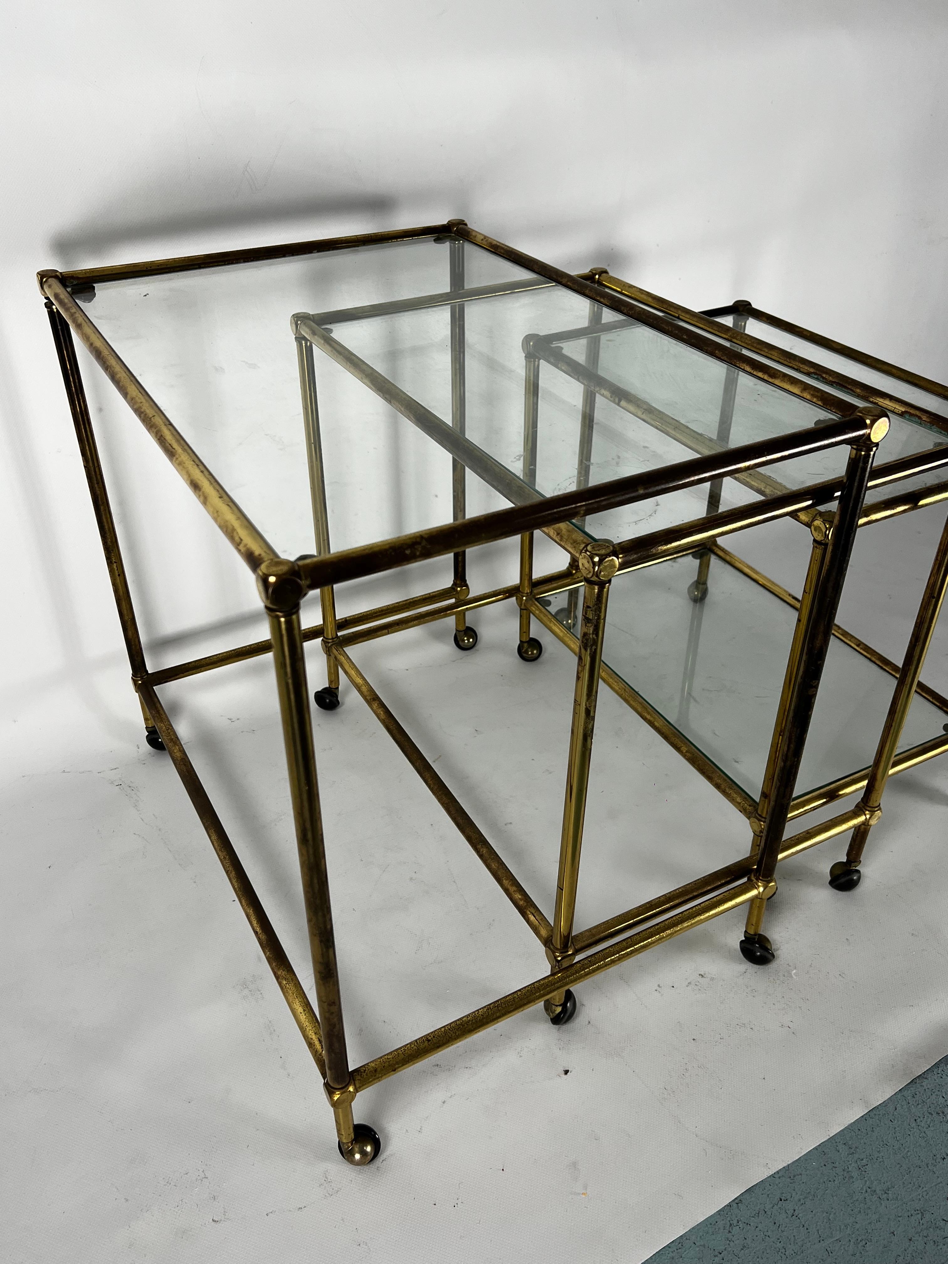 Italian Mid-Century nesting set of three bar carts in brass and glass. Italy 1950s For Sale