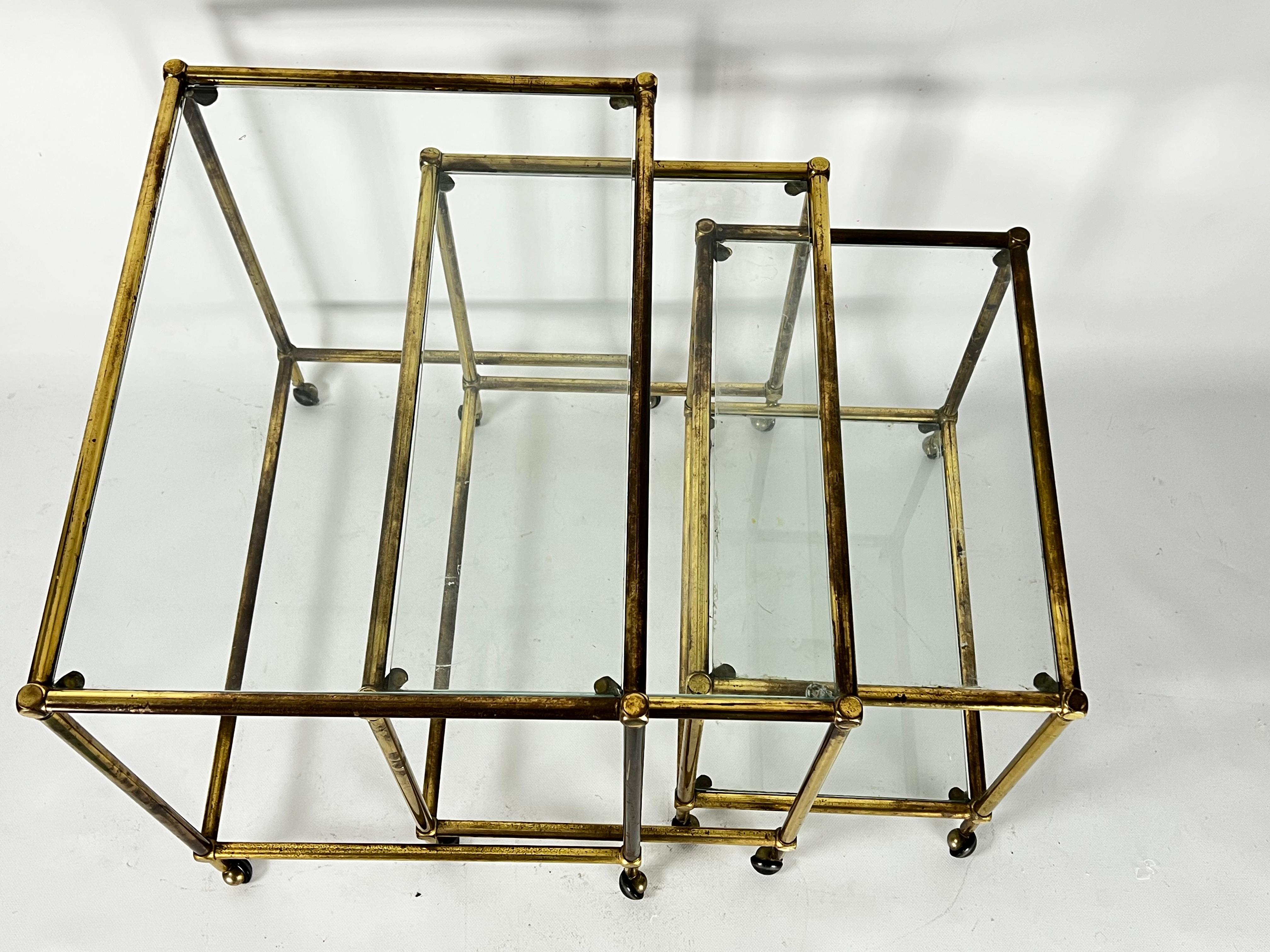 Brass Mid-Century nesting set of three bar carts in brass and glass. Italy 1950s For Sale