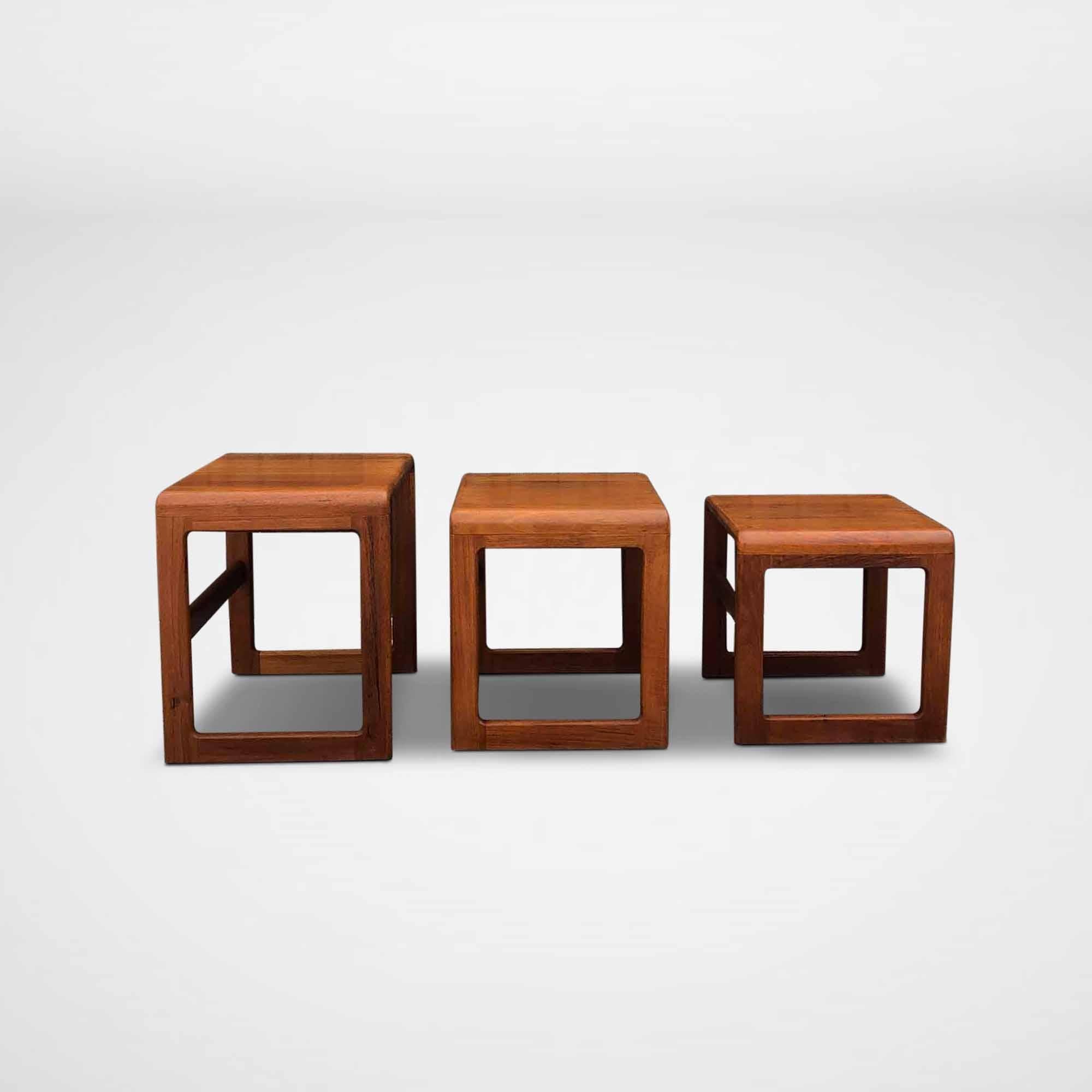 Vintage set of 3 Dyrlund side tables in solid wood. The tables were made in Denmark. These nesting tables slide under each other and do not use a lot of space when stored away. The original attribution mark of Dyrlund is placed on one of the tables.