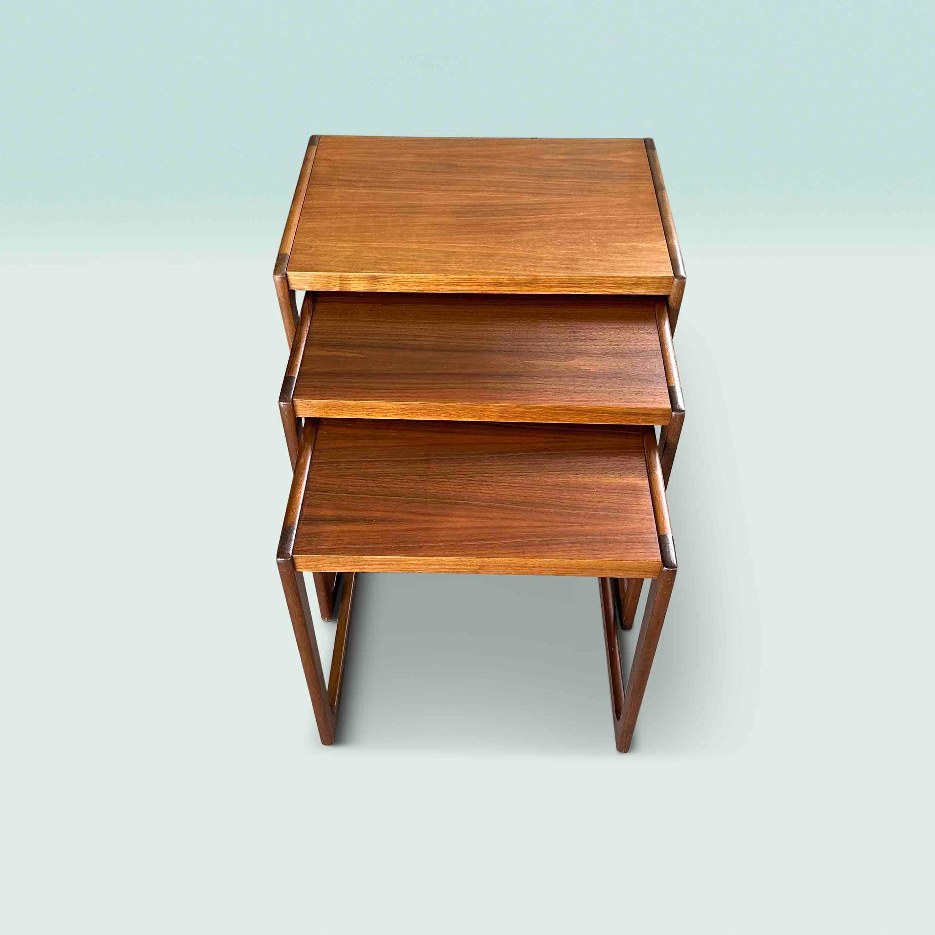 Set of 3 midcentury side tables in wood with a refined finish. These nesting tables were designed by the German Opal Möbel, circa 1960. The coffee tables slide into each other and are therefore easy to put away. The original label is still