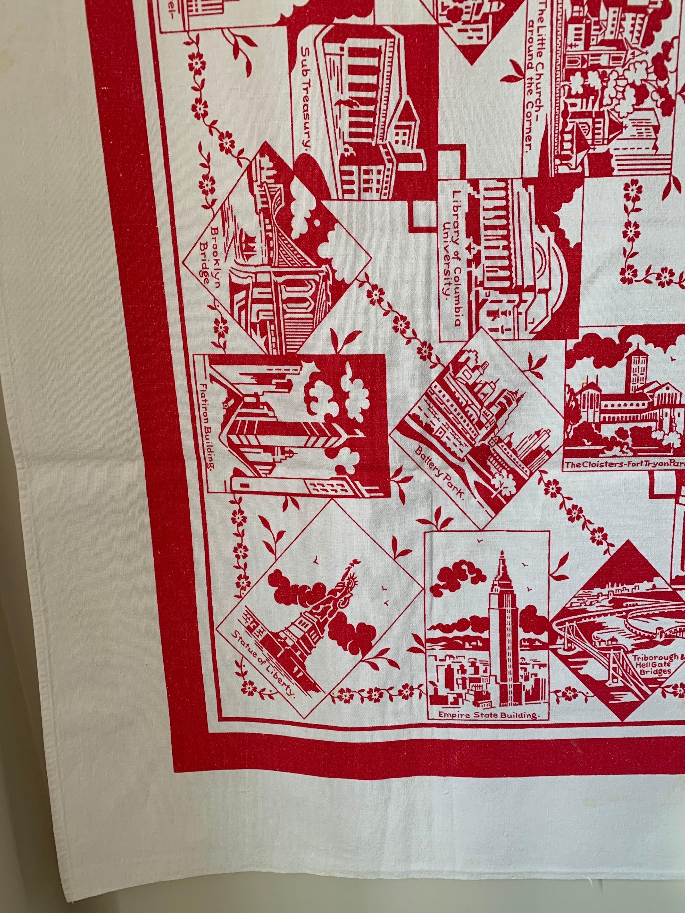 Mid-century New York City souvenir table cloth. White cotton with all over red printed design featuring NYC landmarks.