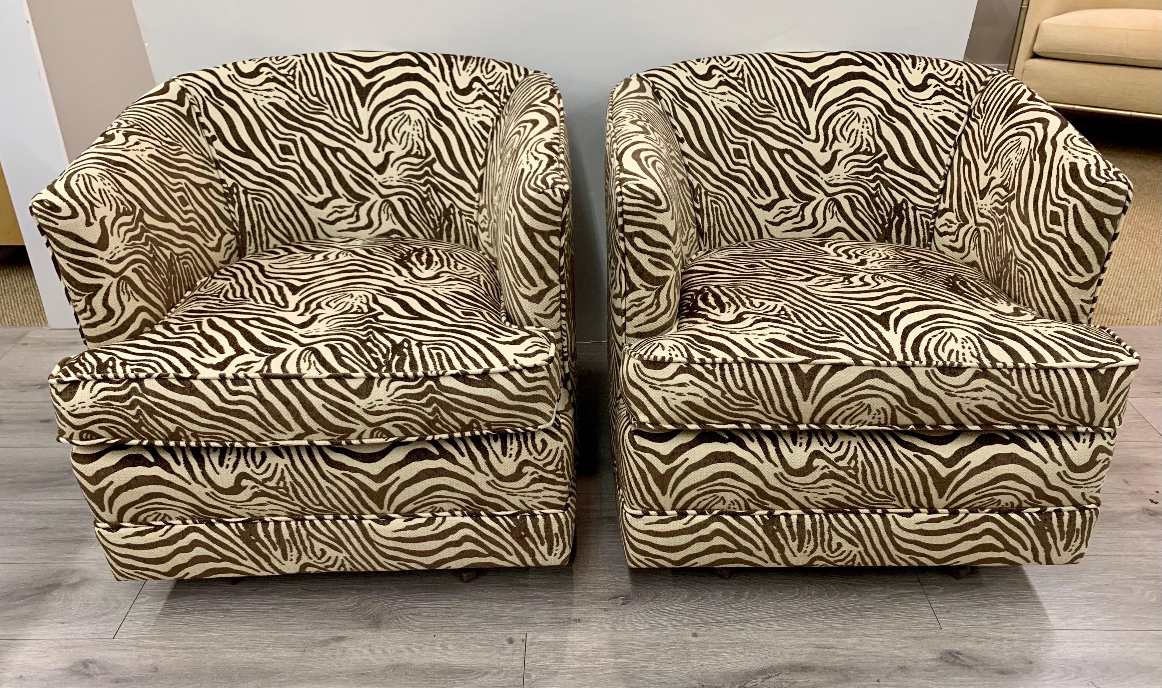 Pair of mid-century barrel back swivel chairs newly upholstered in a zebra print upholstery.