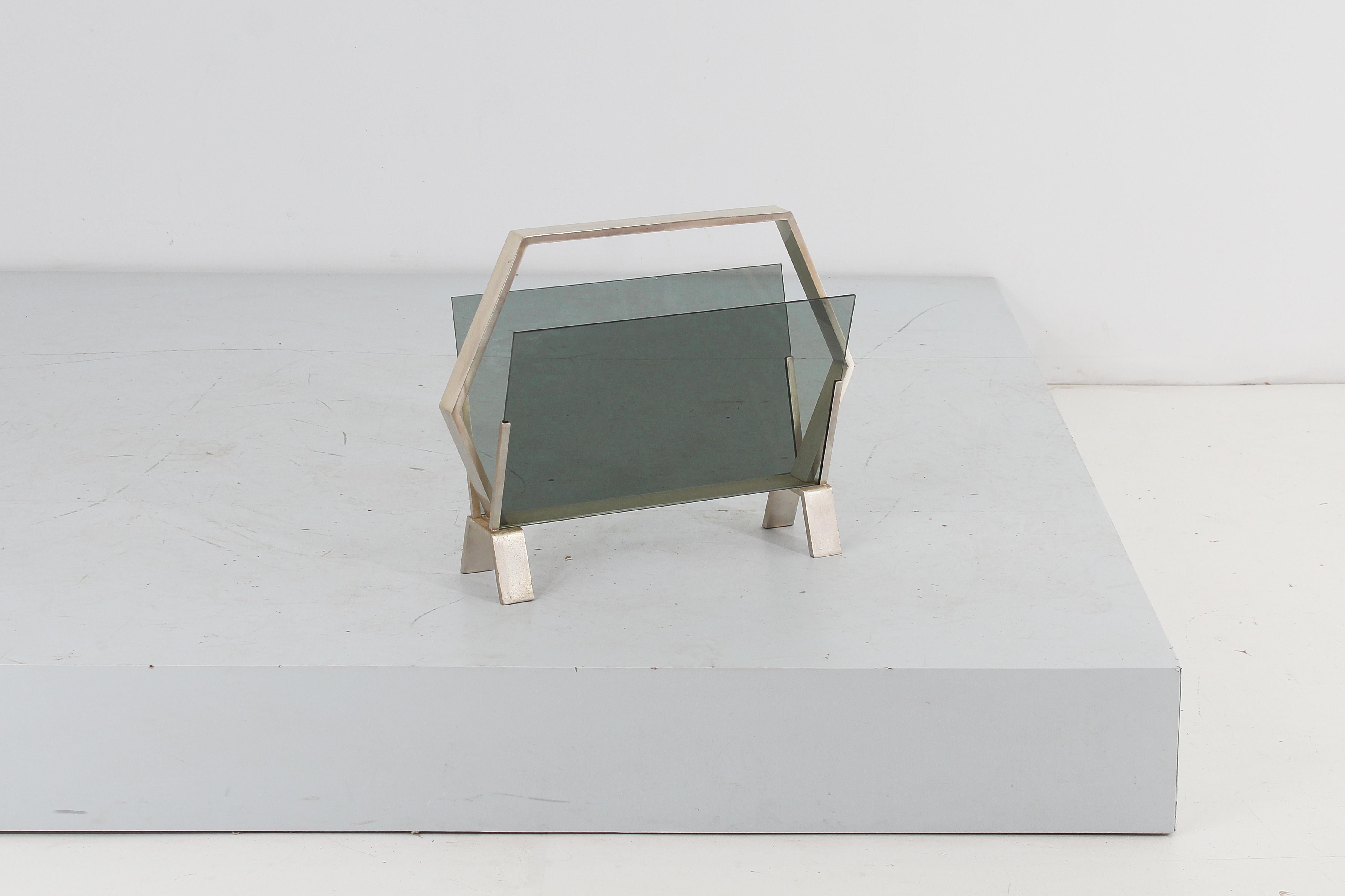 Stilish magazine rack with geometric structure in nickel-plated brass with double oblique panel in smoked glass. Italian production from the 1960s.
Wear consistent with age and use.