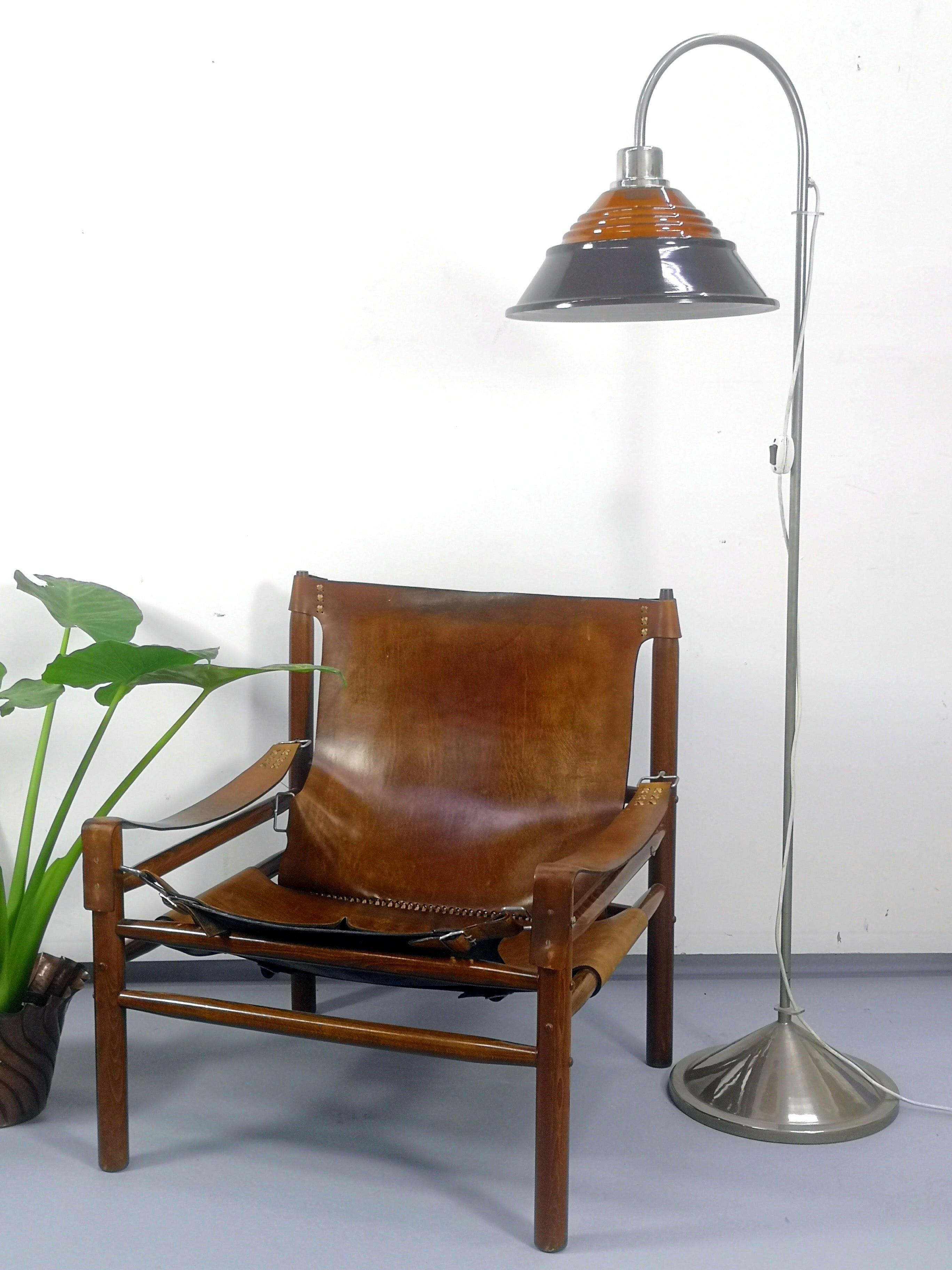 Midcentury nickel-plated floor lamp with amber glass head.