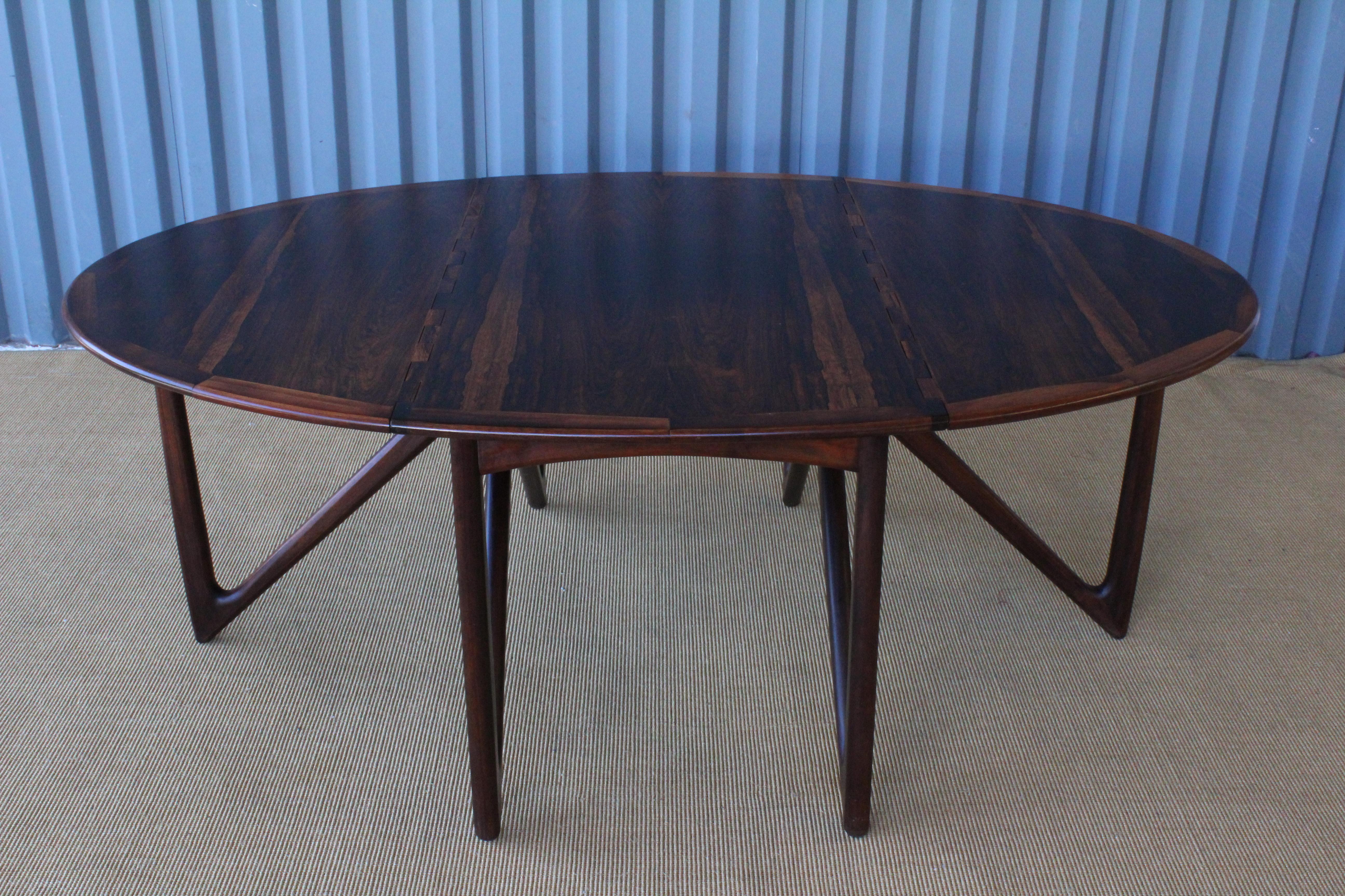 Beautiful dining table in stunning rosewood, designed by Niels Koefoed in Denmark in the 1960s. This tables features two drop leave extensions and folding legs. Wonderful condition with a few minor veneer touch ups. Please see detailed photos of