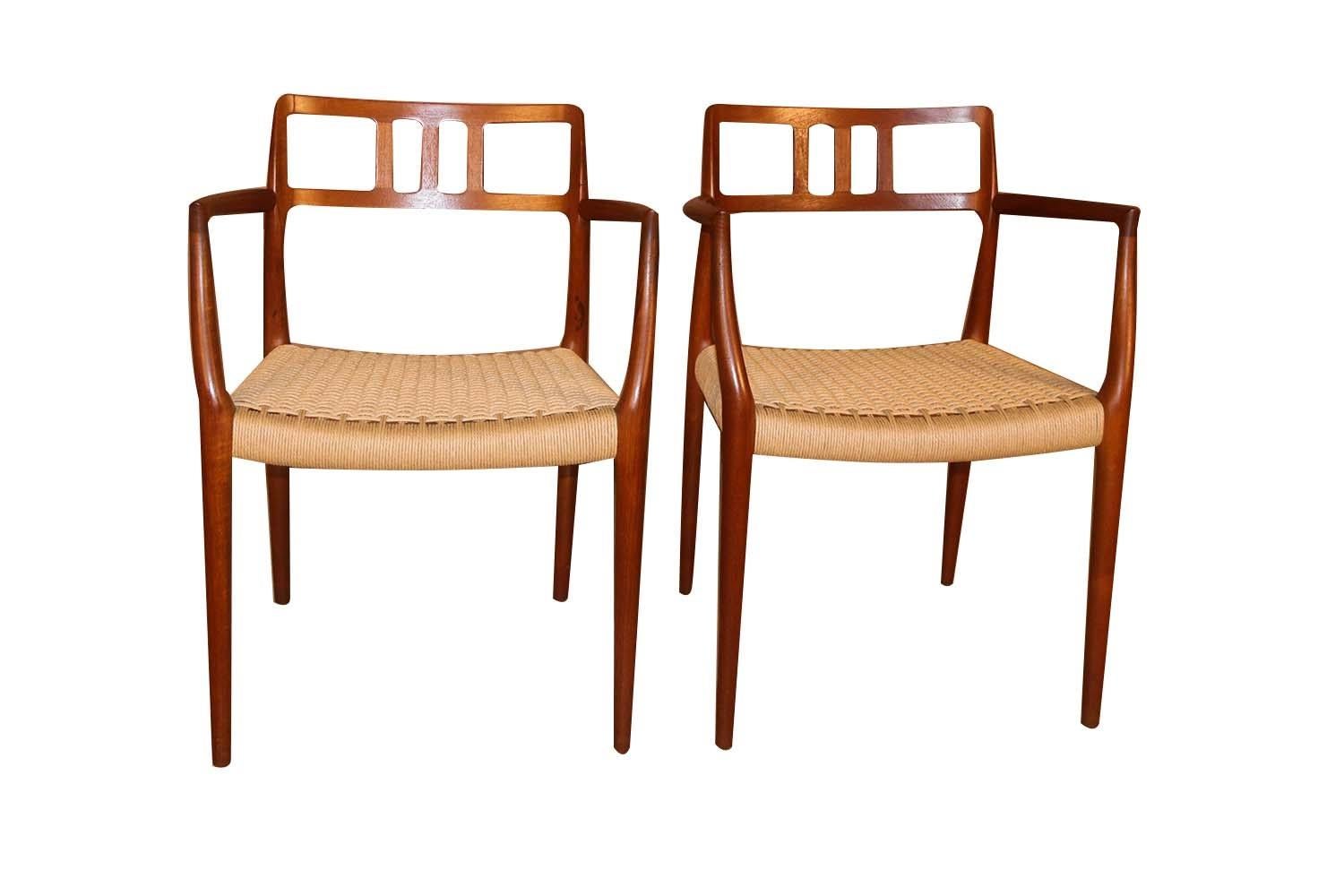 An absolutely stunning pair of midcentury, Danish, Modern, teak armchairs model 64 designed in 1964 by famous designer Niels Otto Moller for J.L. Møllers Møbelfabrik in Denmark. These gorgeous, rarely seen chairs feature beautifully sculpted teak