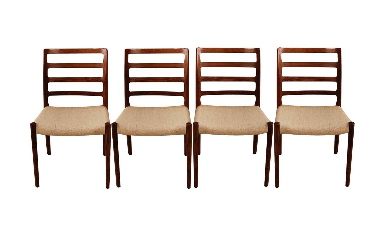 An absolutely stunning set of four midcentury Danish modern rosewood dining chairs model 85 designed by Niels Otto Moller for J.L. Møllers Møbelfabrik in Denmark. Makers stamp (Moller Models made in Denmark) underneath seats. These gorgeous chairs