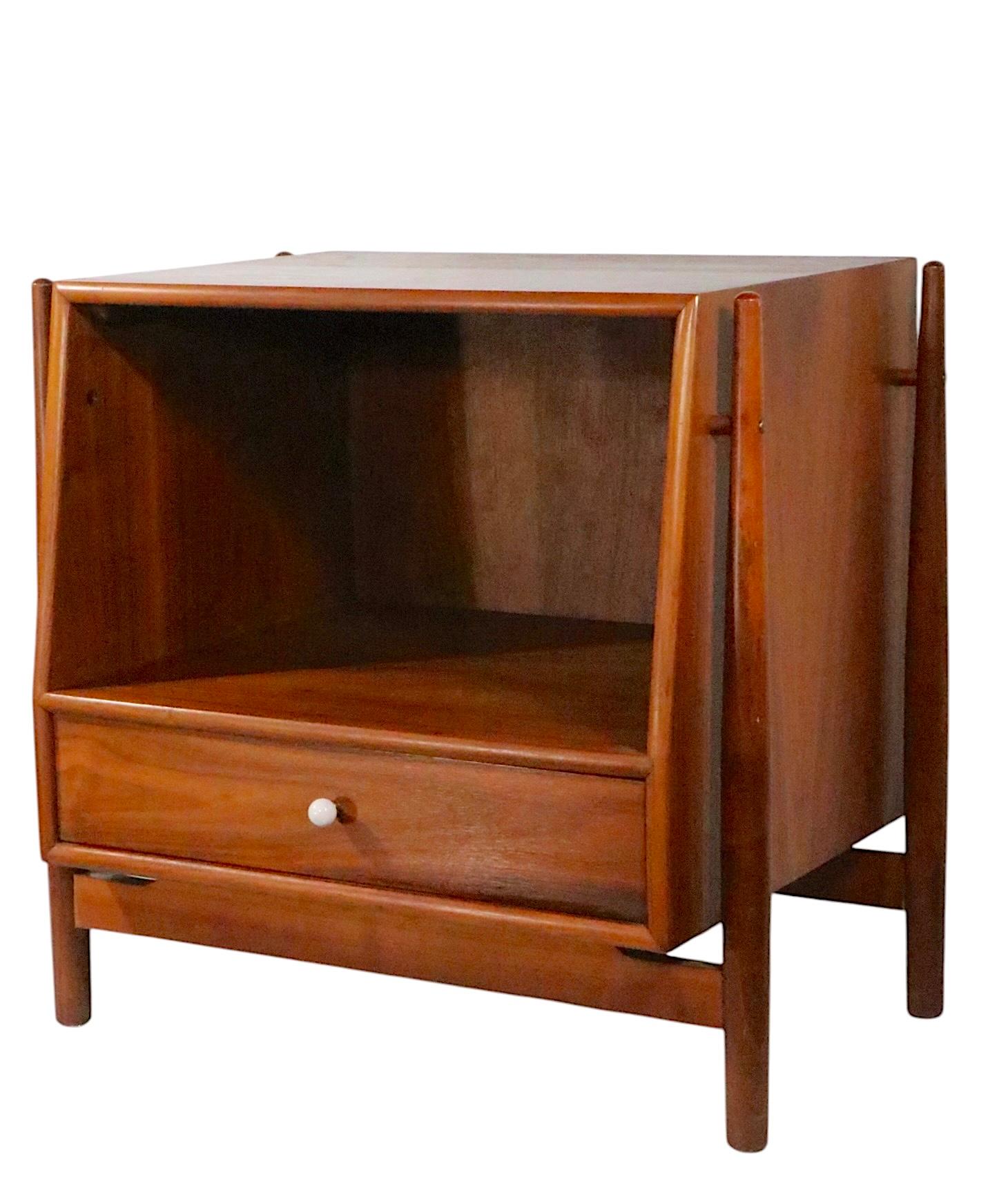 Exceptional  Mid Century night table designed by Kipp Stewart and Stewart MacDougall, for Drexel as part of the iconic Declaration series. The nightstand features a walnut case with a canted profile, open storage on top with a pull out drawer