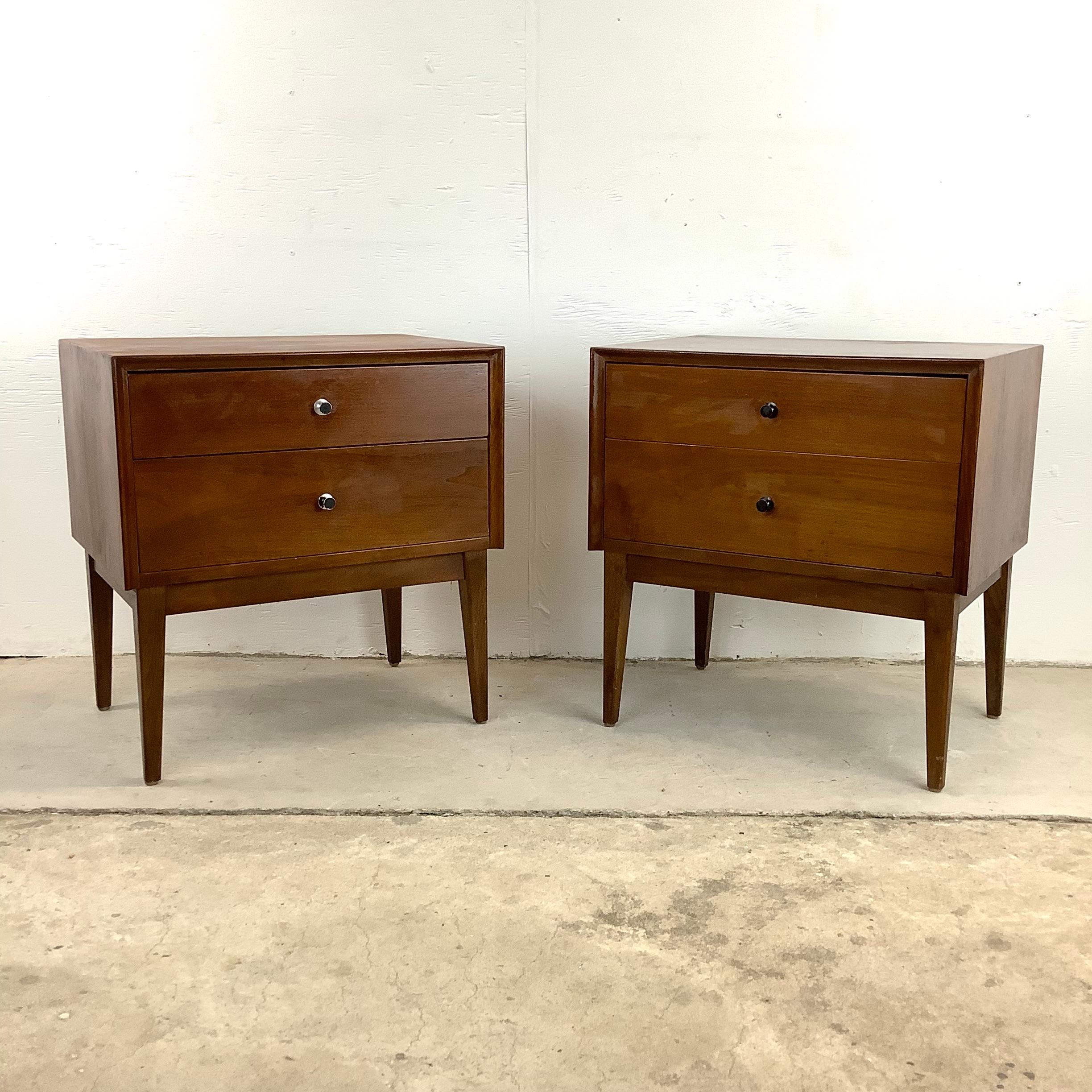 Elevate your bedroom's style quotient with this exquisite pair of American of Martinsville walnut nightstands. Crafted with meticulous attention to detail, these two drawer nightstands are a testament to the artistry and enduring elegance of