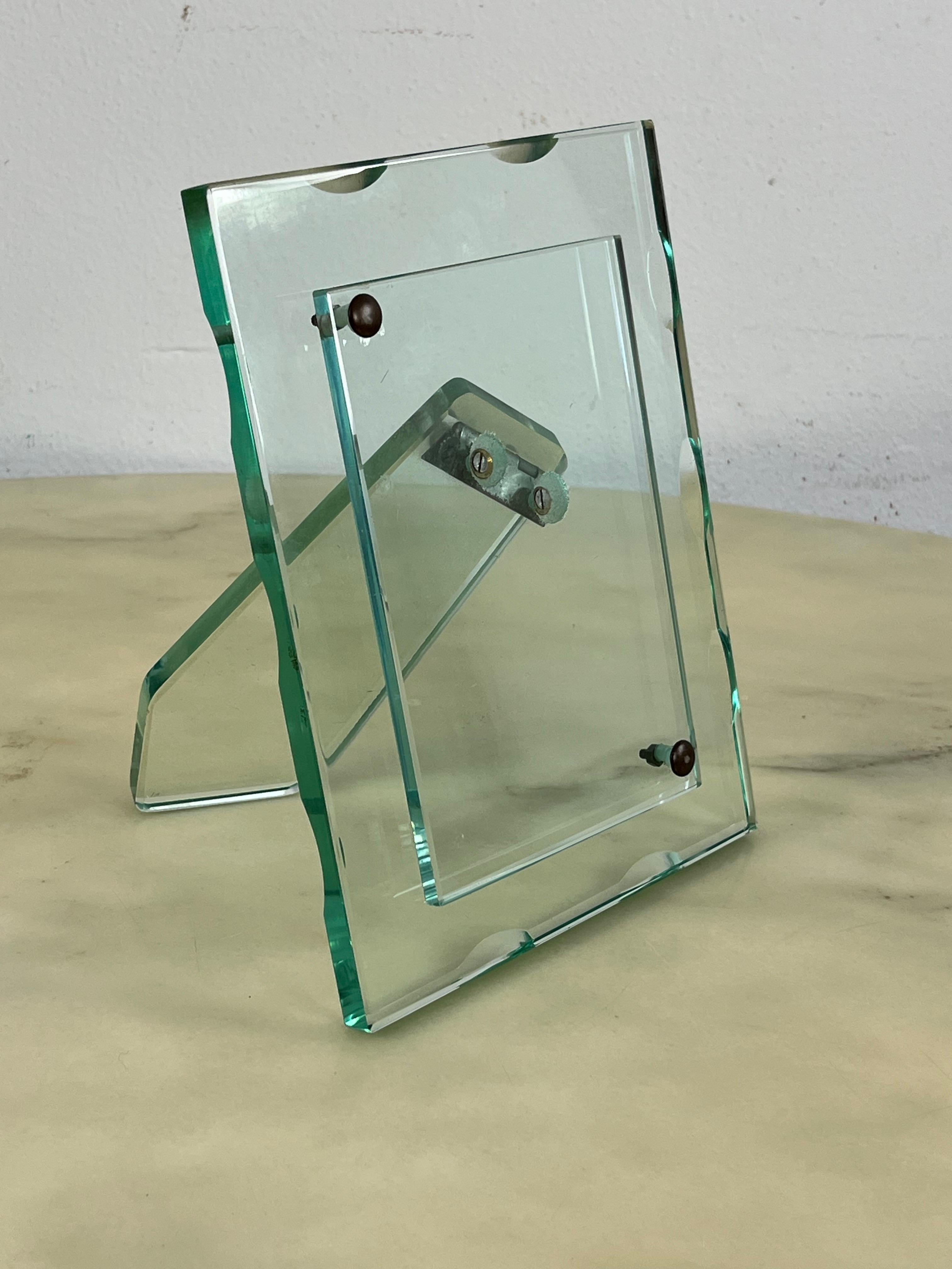 Portafoto in vetro di Murano cesellato verde Nilo di metà secolo attribuito a Fontana Arte, anni '60
Altezza 21,5 cm e larghezza 16,5 cm.
Lo spazio della fotografia misura 16 cm x 11 cm.
Condit e in buone condizioni.