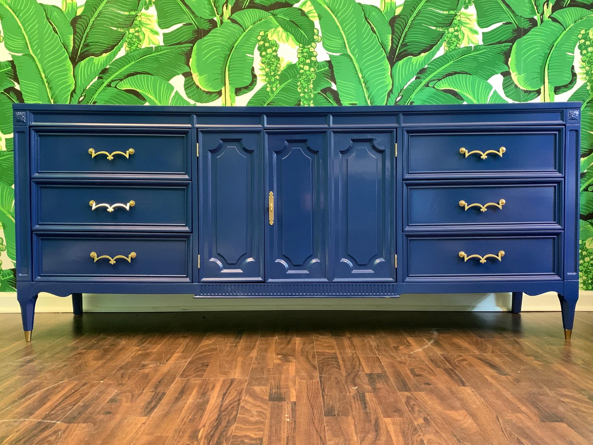 Midcentury dresser by American of Martinsville features brass hardware, brass feet, and asymmetrical centre doors revealing centre drawers. Finished in high gloss blue. Very good vintage condition with minor imperfections to the newly lacquered
