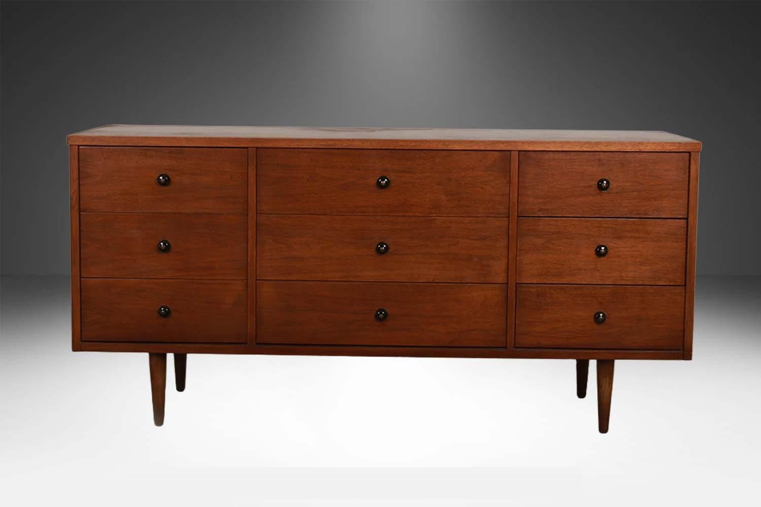 Beautiful Mid-Century Modern nine drawer Dresser by Bassett. This is a beautiful example of Mid-Century craftsmanship, featuring nine drawers for plenty of storage. An extremely well made and solid piece in good condition with simple elegant lines
