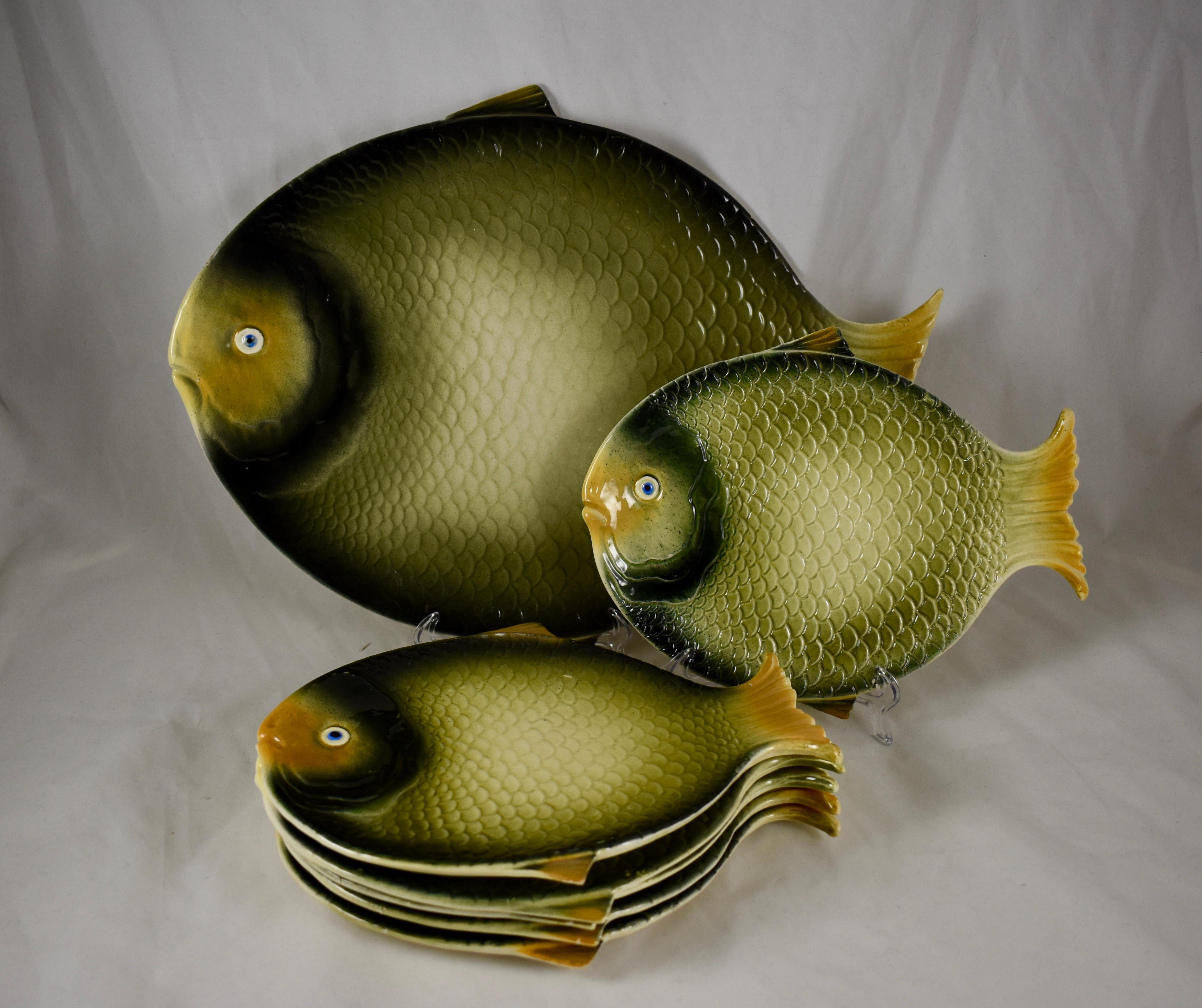 From the Barrettoni già Antonibon pottery in Nove, Northern Italy, a Mid-Century Modern Era earthenware fish service consisting of a large serving platter and six individual plates. 

Each piece is formed as a fish with dimensional mold work of