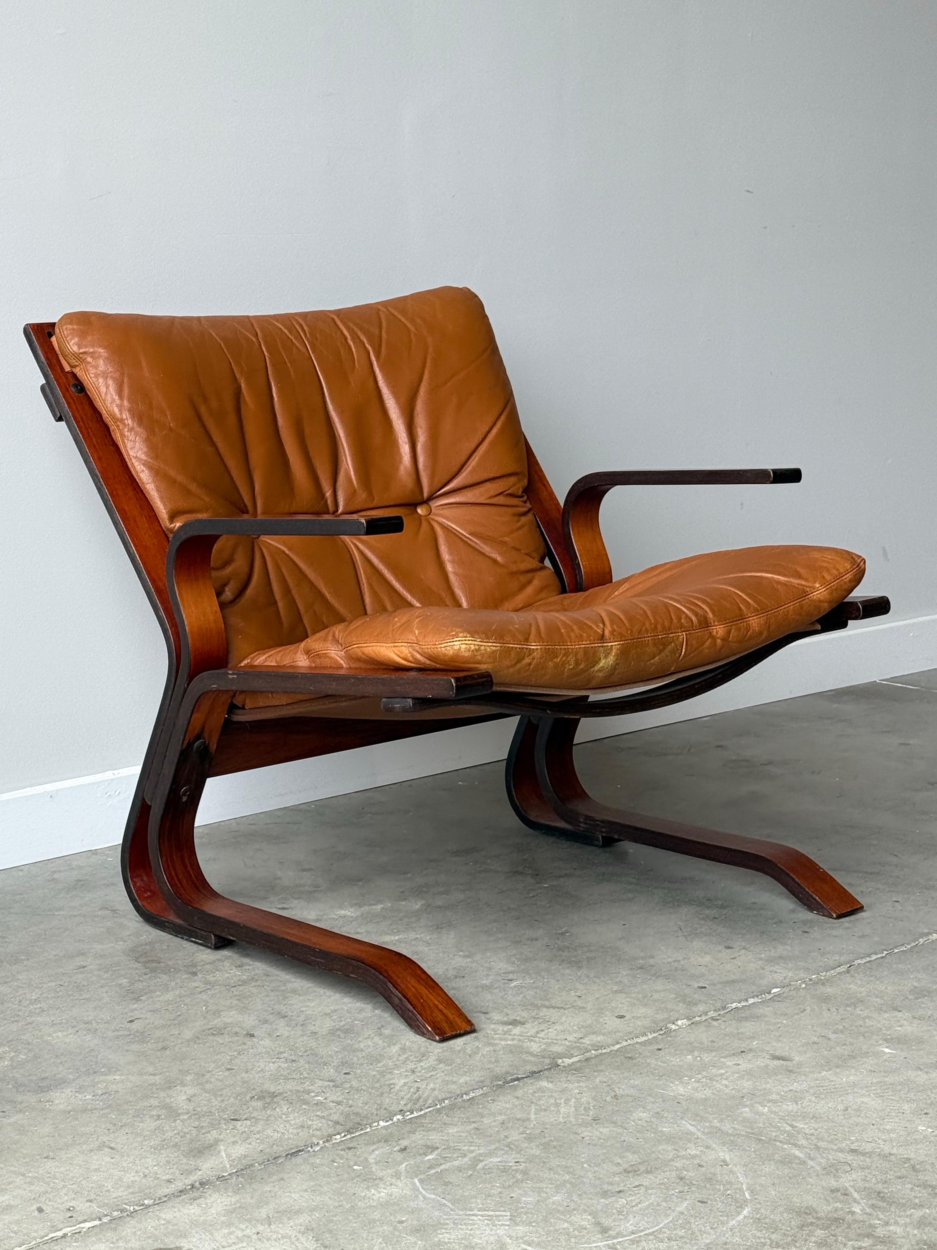 Mid-Century armchair designed by Oddvin Rykken for Rybo and Co. Made in Norway circa 1960s. The sleek wooden frame made from beech wood is an absolute show stopper. Showcasing stunning bentwood curved armrests and legs that capture a low-slung