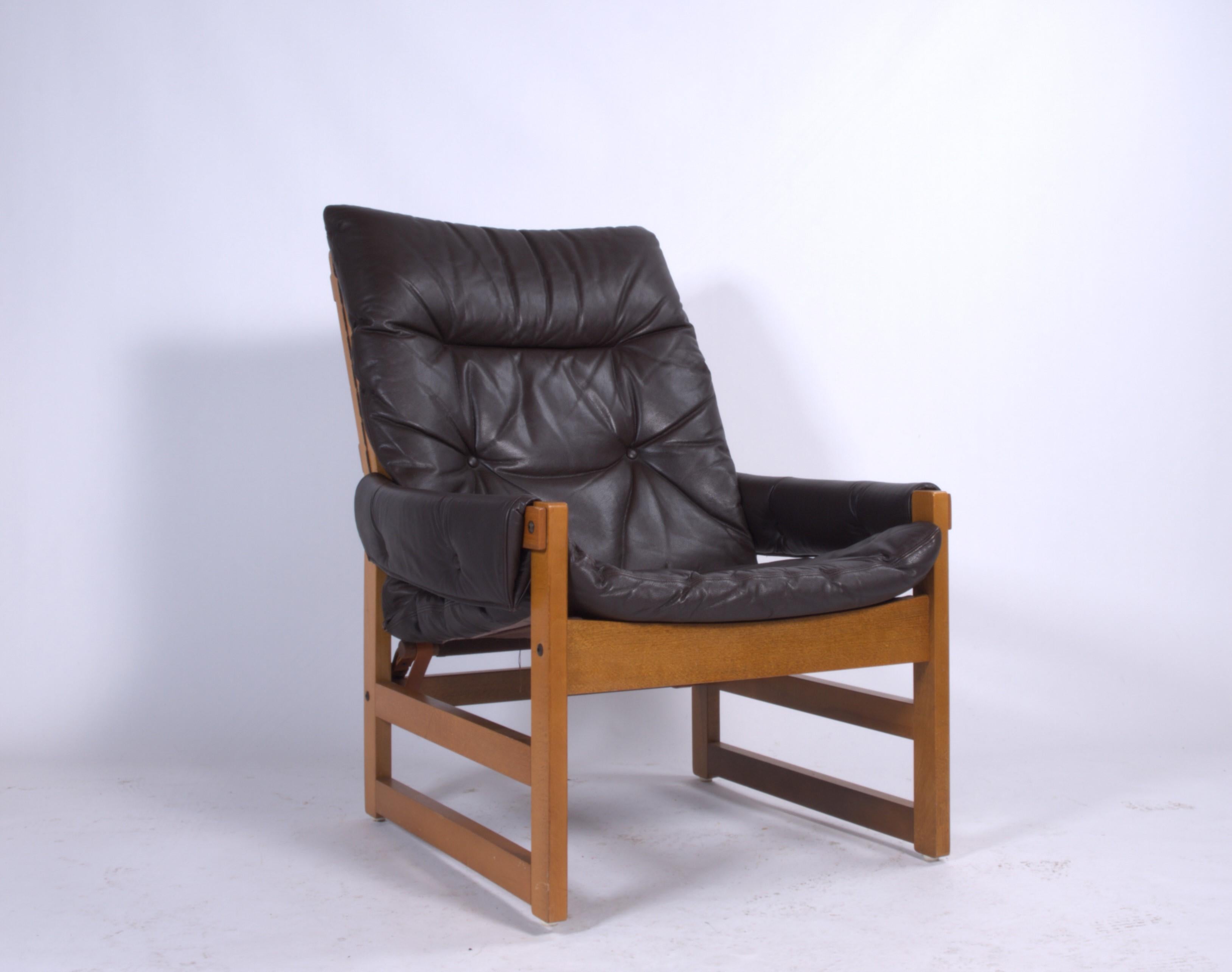 This solid Scandinavian armchair with an ottoman is a vintage gem that will elevate the style of any living space. It is in great condition and has had only one owner since the 1970s, adding to its unique history and appeal.

Designed by the