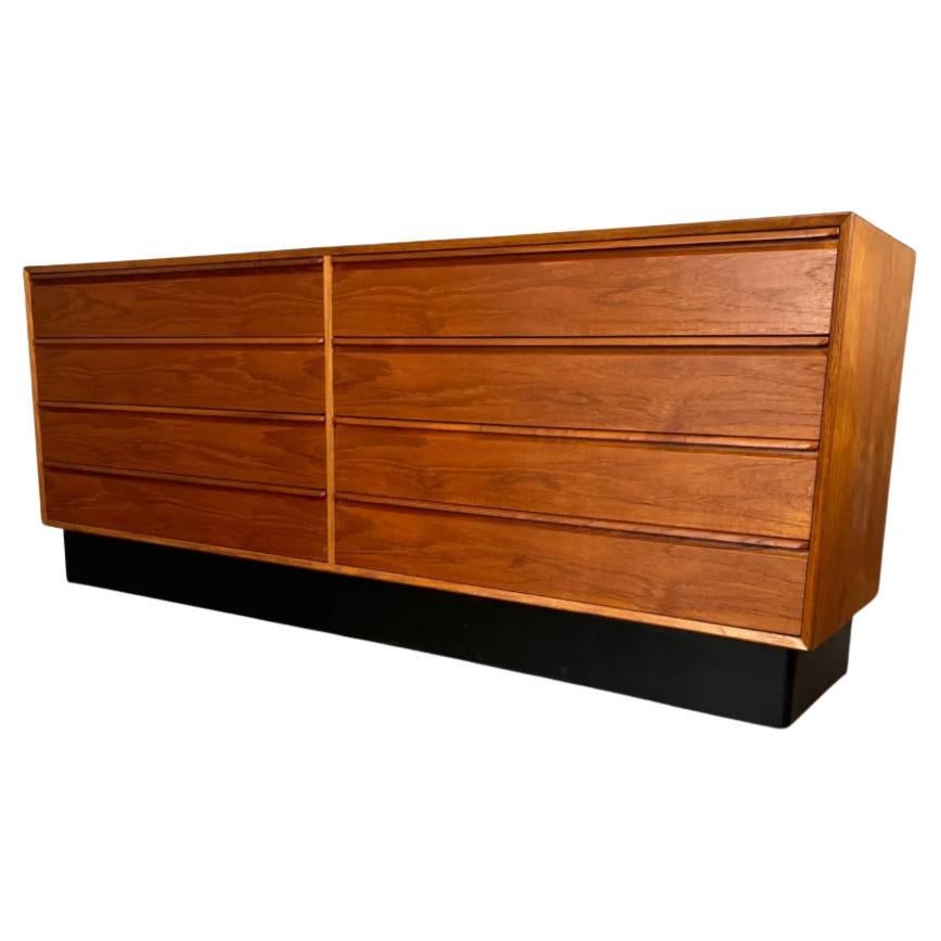 Beautiful Mid-Century Norwegian modern low teak 8-drawer dresser credenza by Westnofa. Great design and great vintage condition - clean inside and out. Drawers slide smooth with dovetail construction and carved handles. Sits on a black lacquer