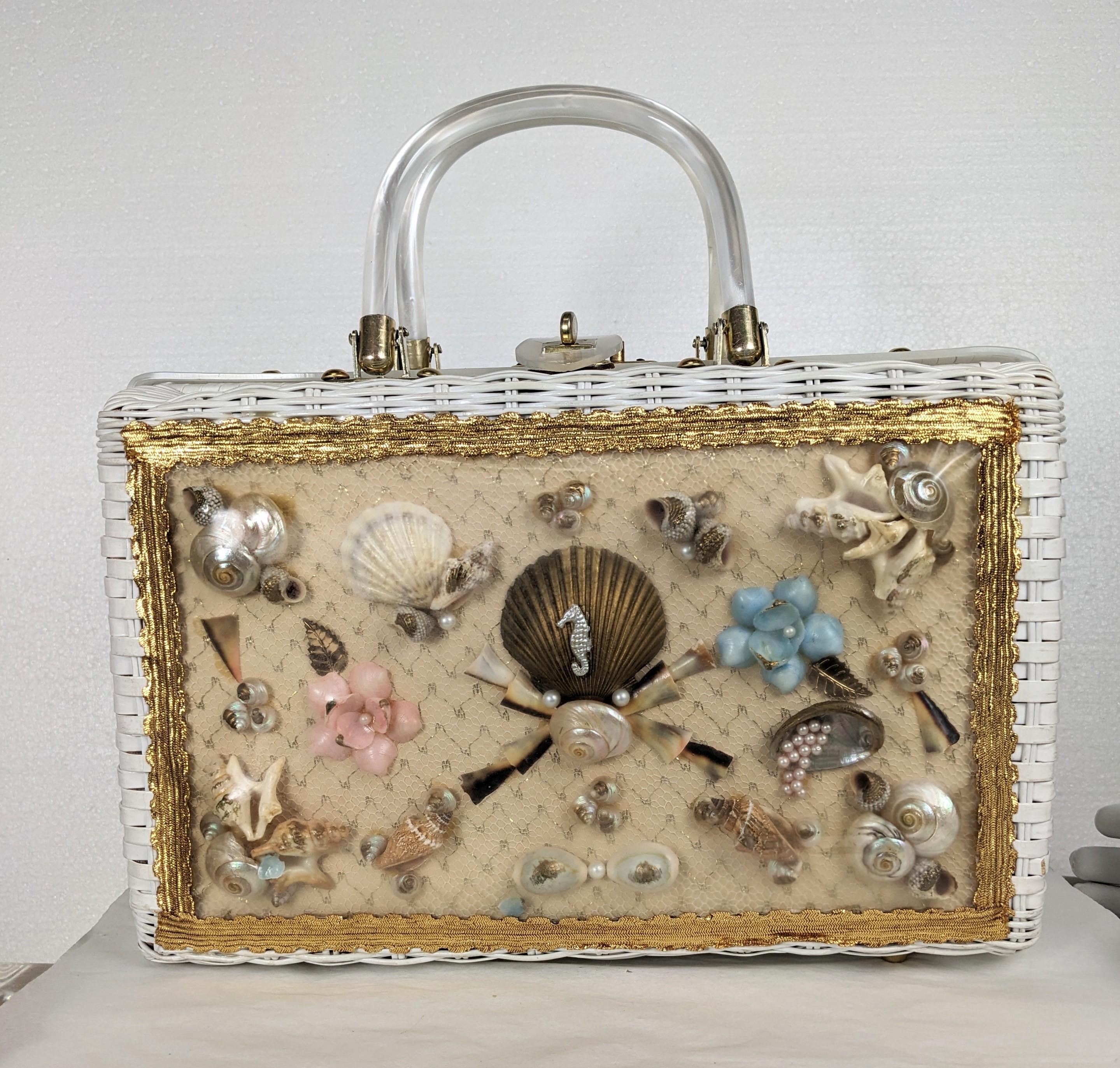 Mid Century Novelty Wicker Seaside Themed Bag from the 1950's. Made in Hong Kong for a resort shop in Hollywood, Florida. White wicker with a sea scape of shells, coral and faux pearls caught under clear vinyl and framed in gold lame bullion trim.