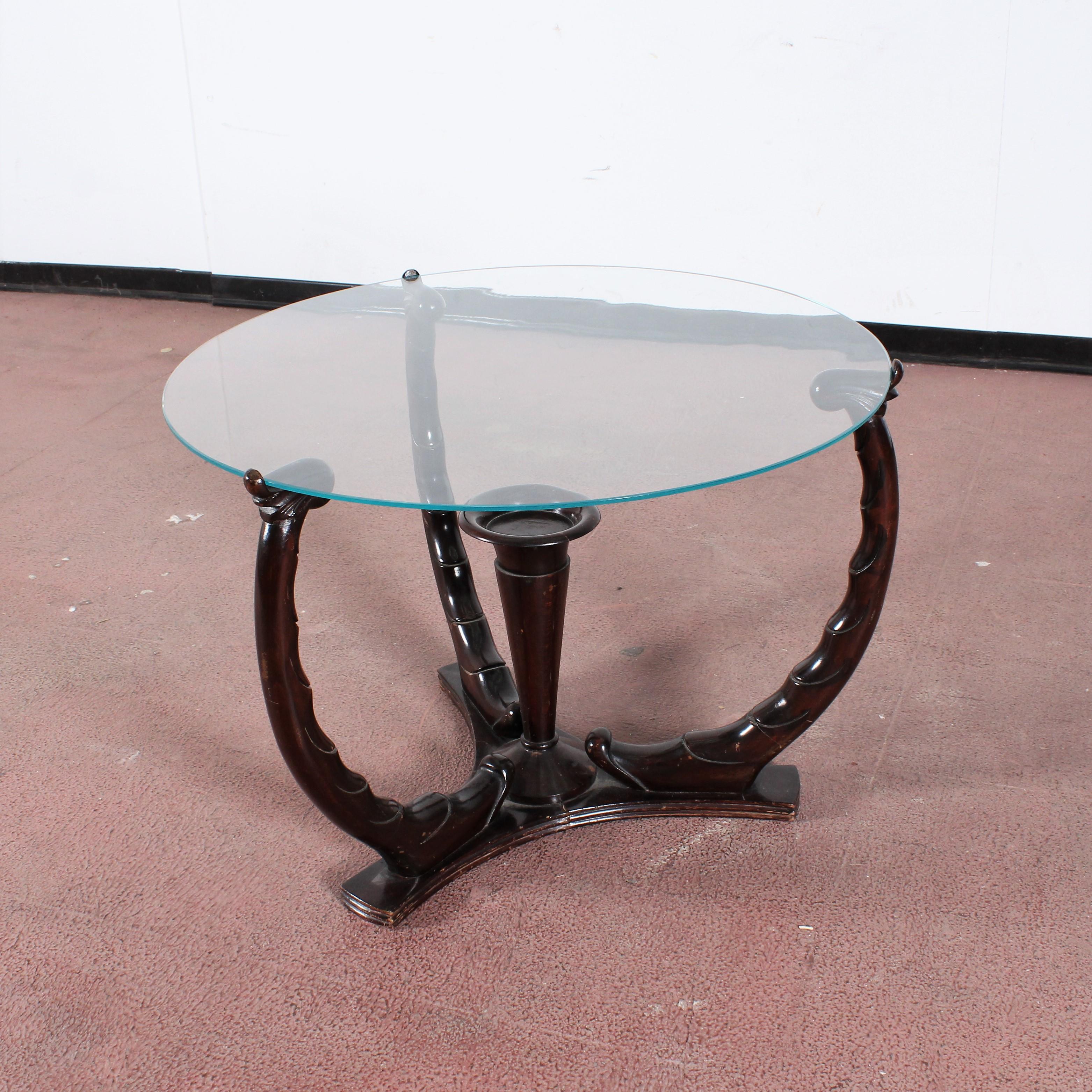 Very beautiful wood round coffee table with clear glass top.
The three elegant legs and the central body, in dark wood with intertwining motifs, offer an extraordinary optical effect. Osvaldo Borsani style, 1950s, Italy.
Wear consistent with age