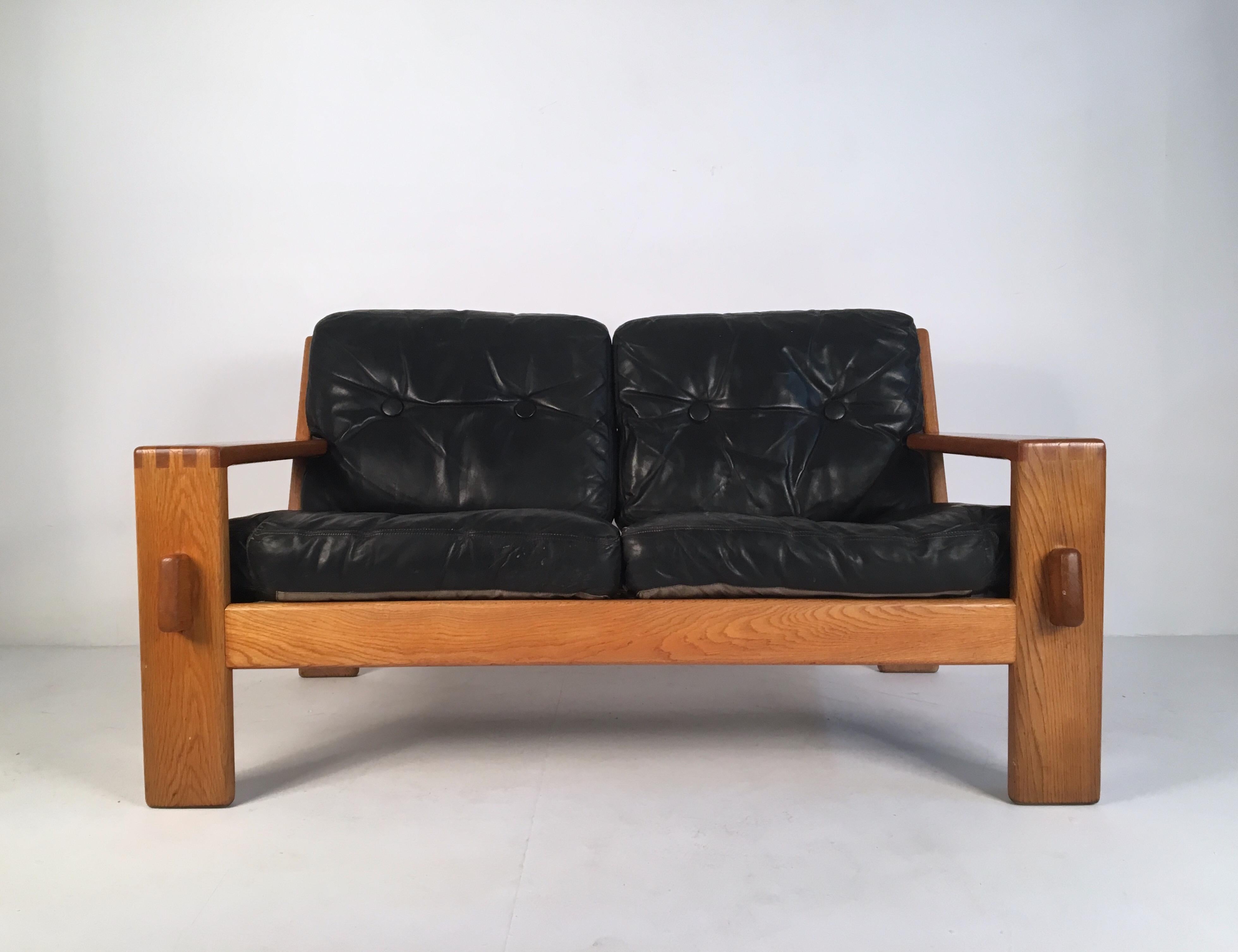 Leather and solid oak sofa designed by Esko Pajamies for Asko, Finland, circa 1960.

Leather buttoned cushions upon a solid oak frame with a very eye-catching finger joint detail.