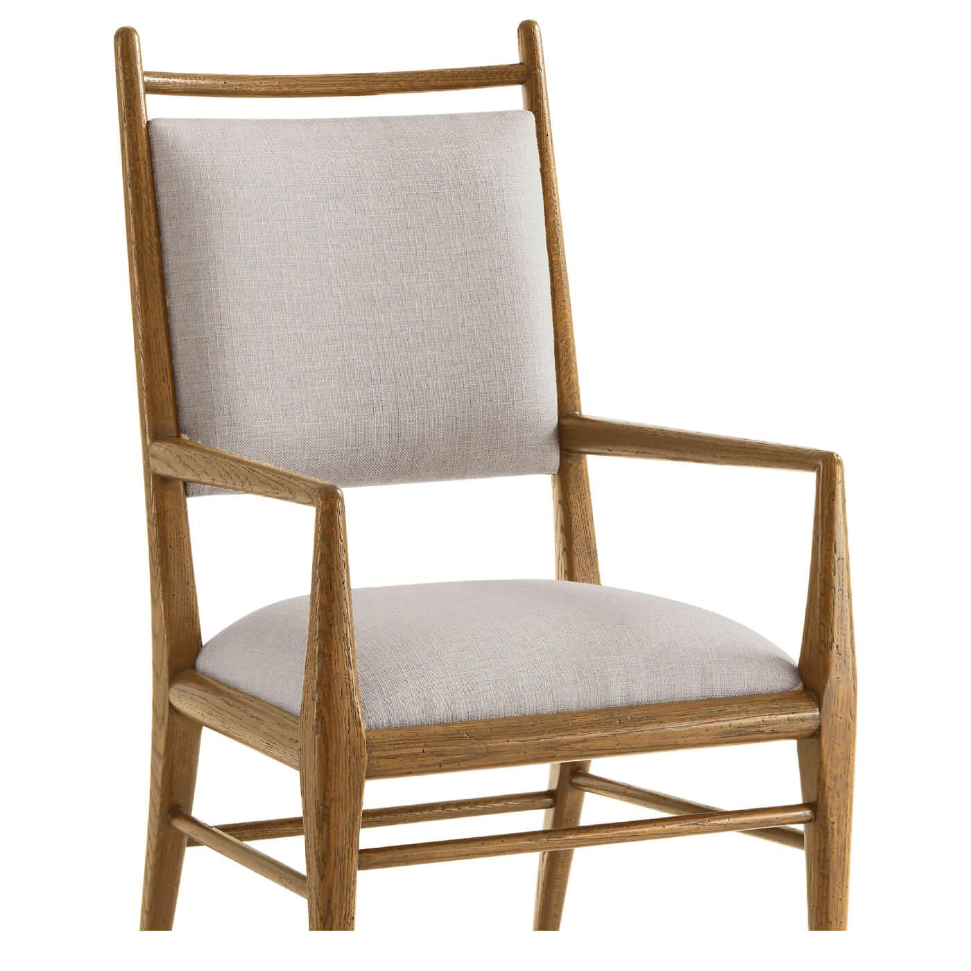 Mid Century style light oak dining armchair in our dawn finish, with a padded back and seat upholstered in performance linen fabric adds comfort and sophistication to this timeless design. Raised on tapered legs joined by a supportive