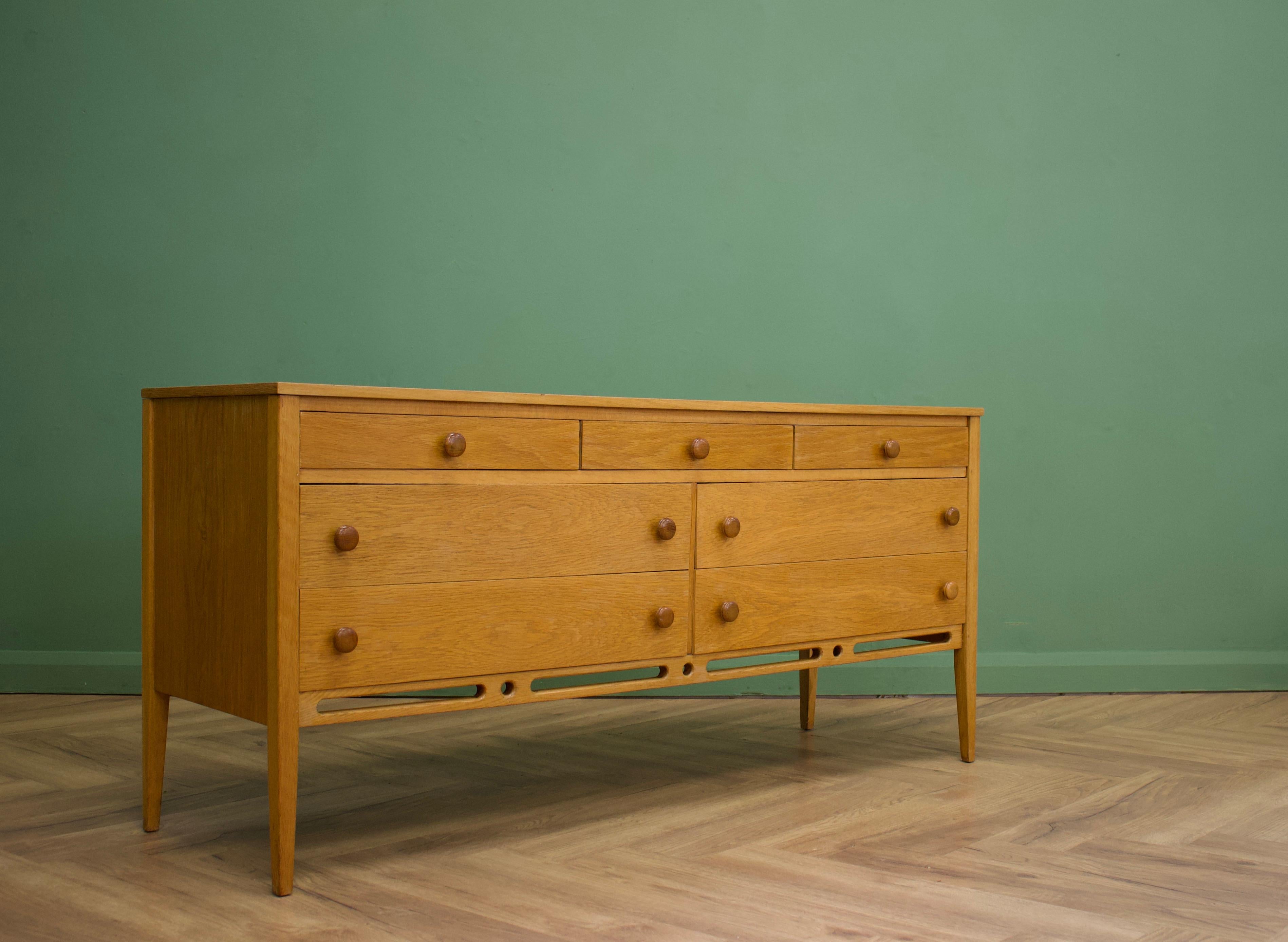 - Midcentury dresser or compact sideboard
- Designed by John Herbert.
- Manufactured in the UK by Younger.
- Made from oak and oak veneer.