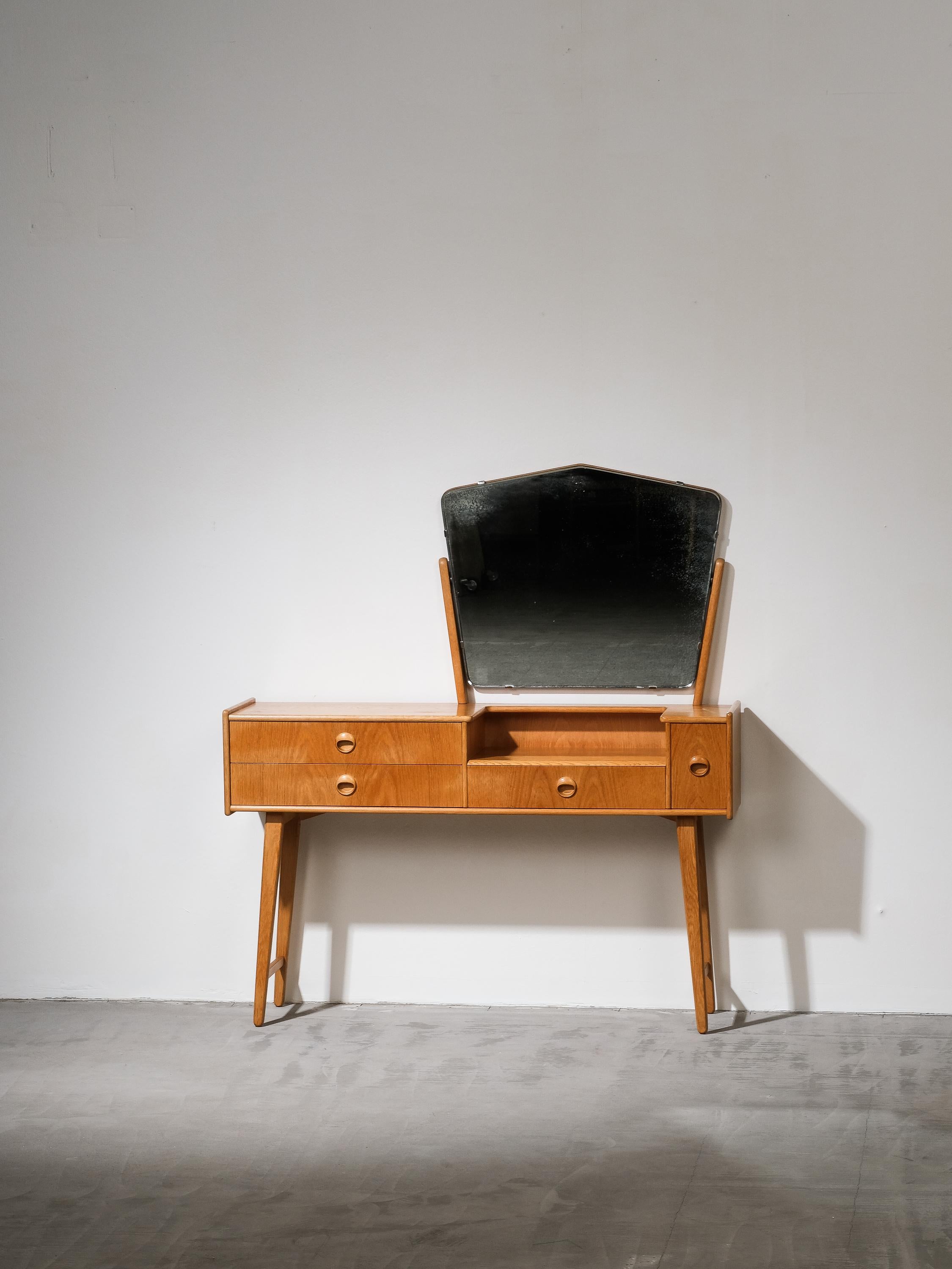 Exquisite 1950s dressing table in oak produced by Talgø Møbler, Norway. Adjustable mirror with brass fittings, 4 front drawers with beautifully shaped oak pulls.