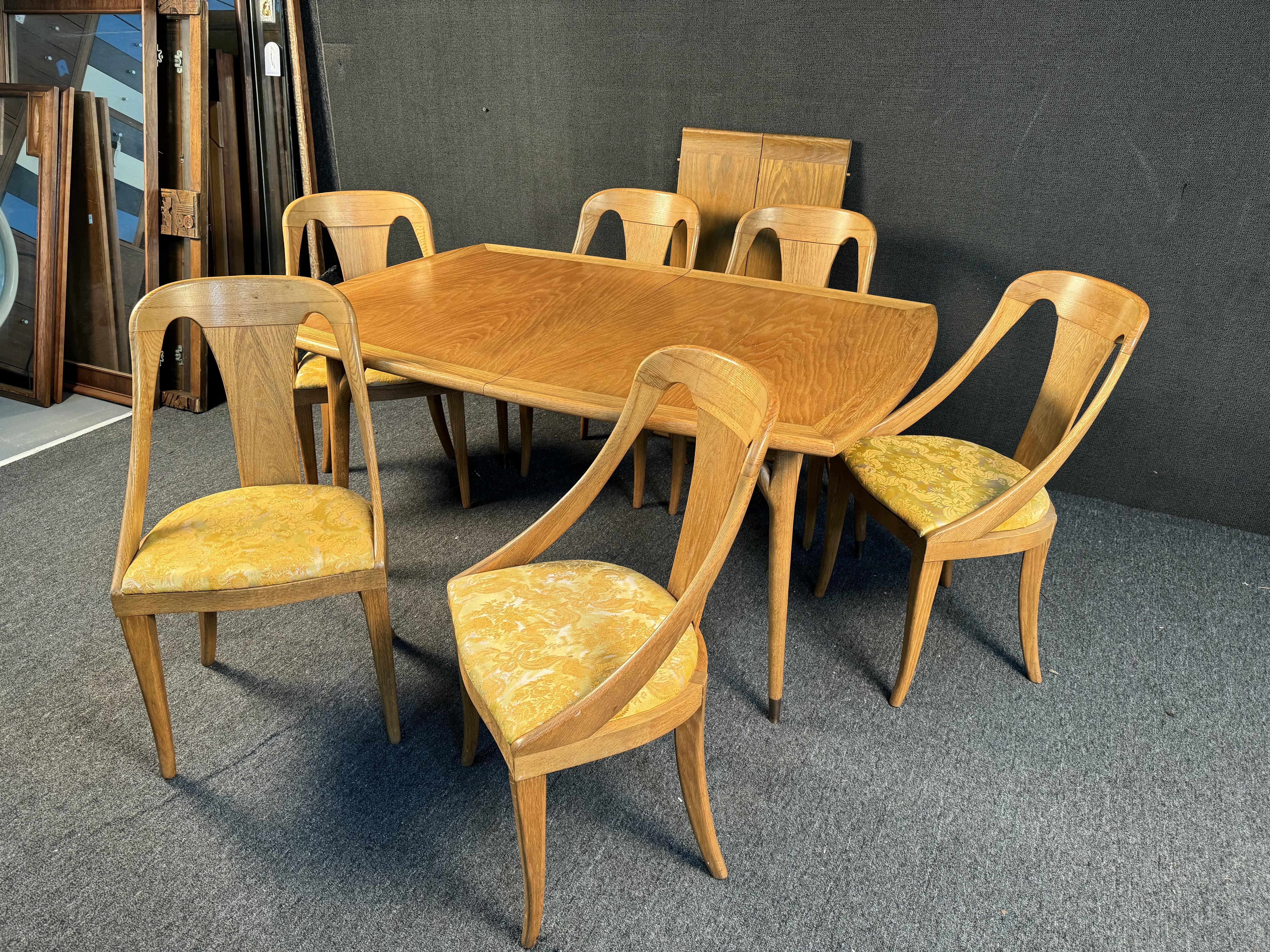 Superbe table de salle à manger en chêne du milieu du siècle par Jack Van Der Molen. Comprend une magnifique table de salle à manger en chêne avec 2 feuilles et six chaises avec un motif Satiny Gold. Veuillez confirmer la localisation avec le