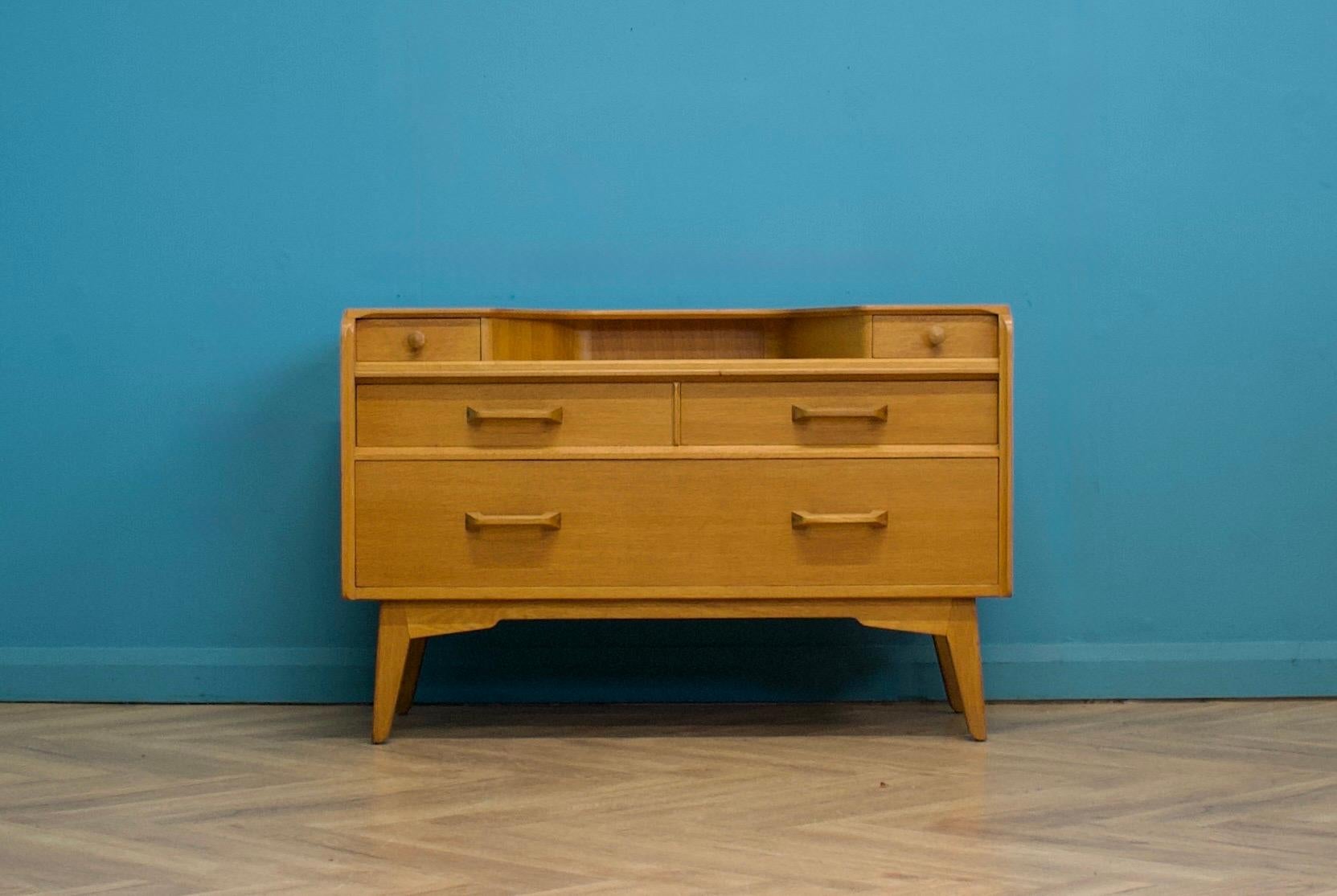 Ce buffet ou coiffeuse en chêne de la gamme G-Plan (E Gomme) Brandon date des années 1950.

 Cinq tiroirs
