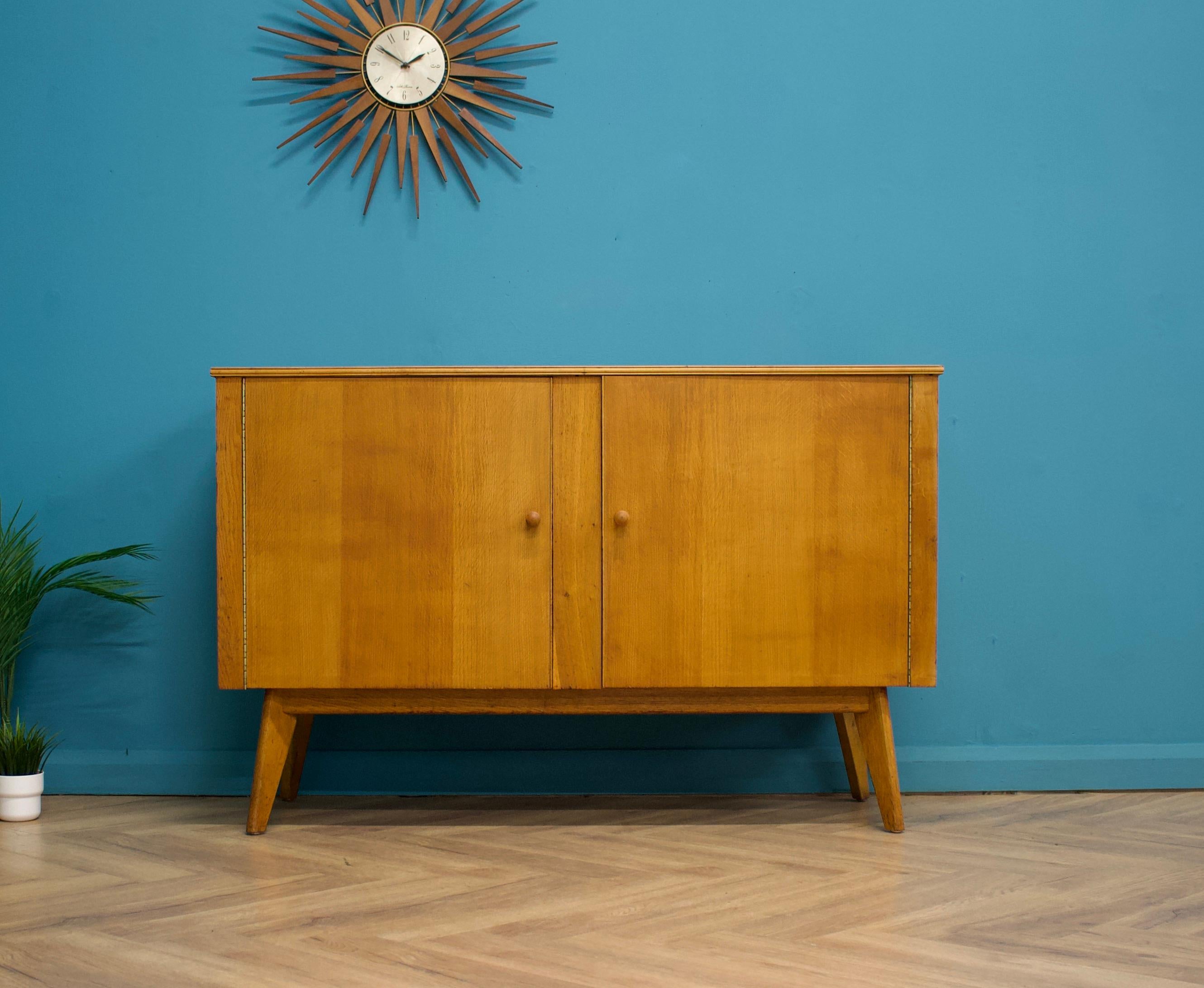 An oak sideboard from Morris of Glasgow
Featuring an internal shelf and drawer

The attractive legs are slightly tapered and the handles are solid wood
