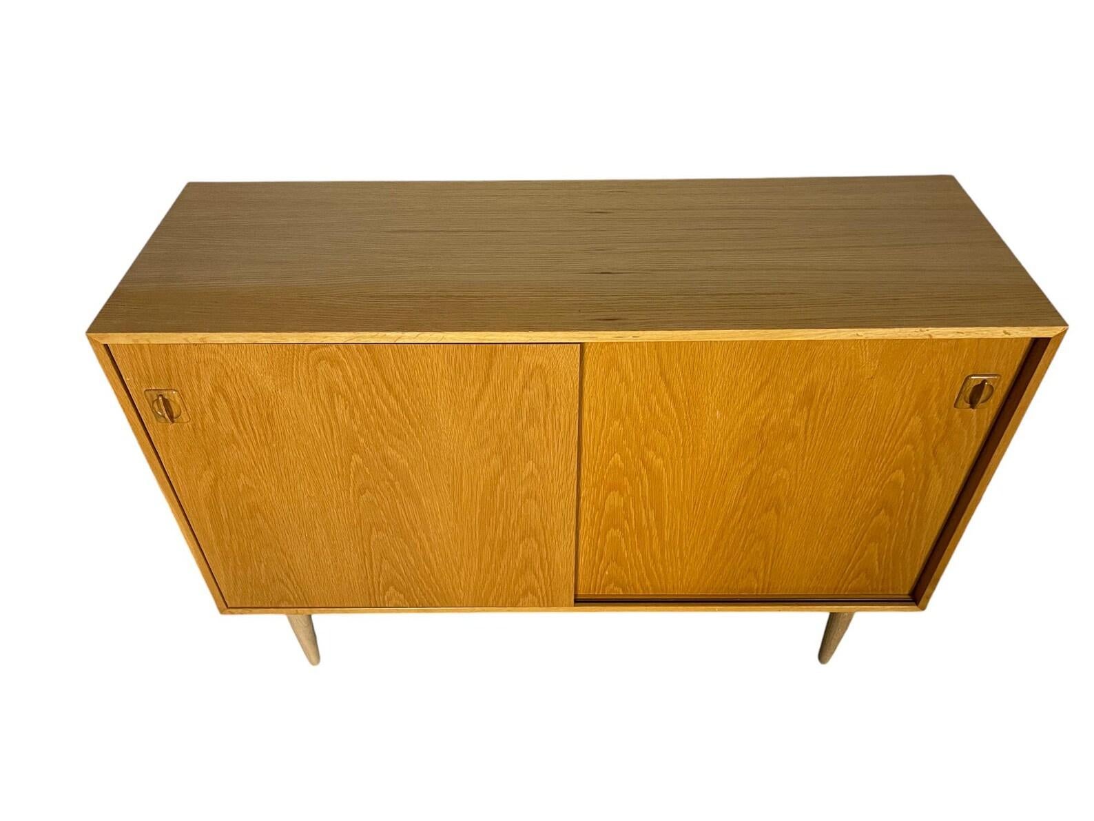 This mid-century modern sideboard is a stunning addition to any home decor. With its beautiful oak finish and sliding doors, it provides ample storage space while maintaining a sleek and stylish look. The credenza style adds a touch of